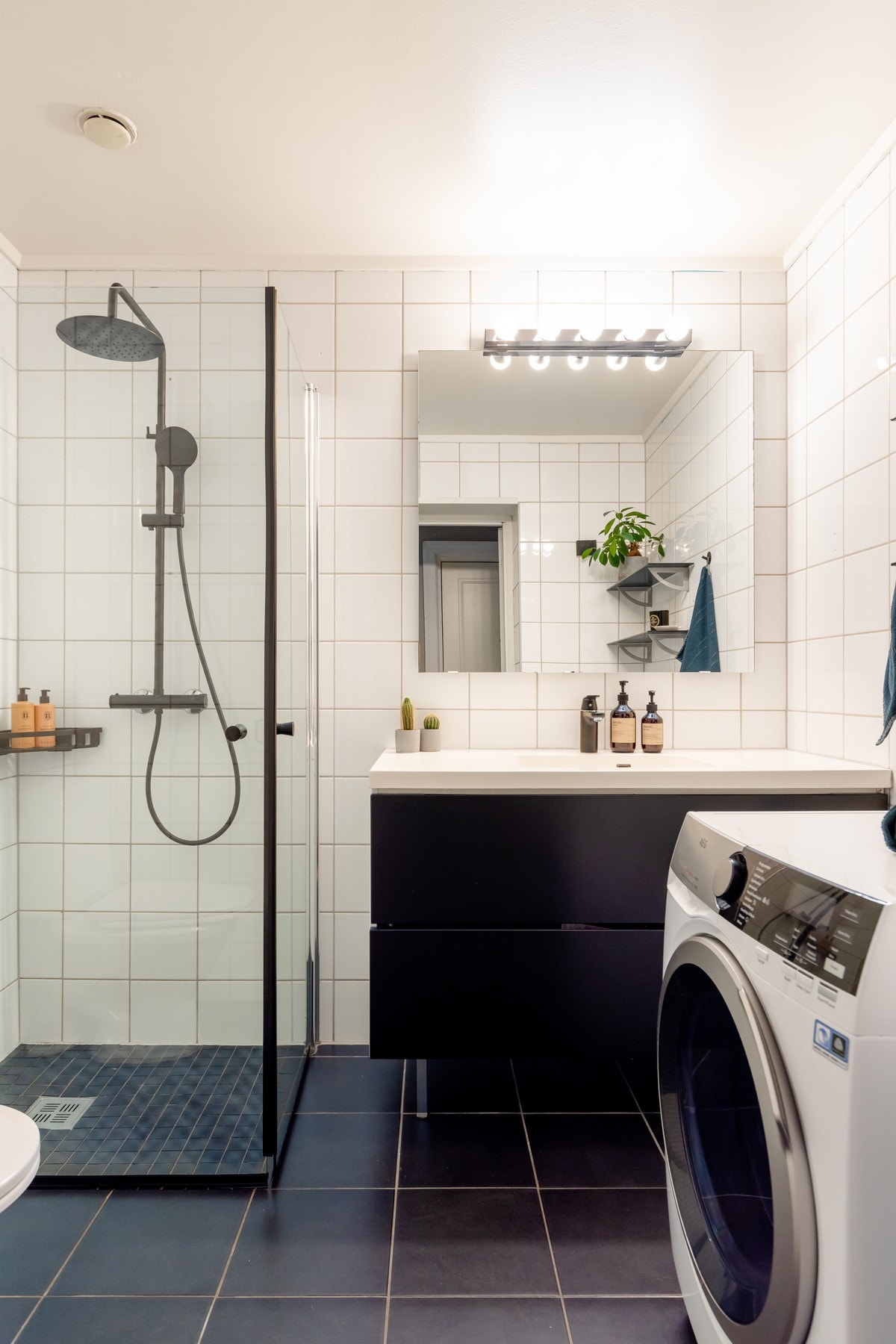 Badet er innredet med vegghengt servantinnredning md ovenpåliggende servant og ett-greps armatur, speil og belysning på vegg over servant, samt gulvstående toalett. Galleribilde