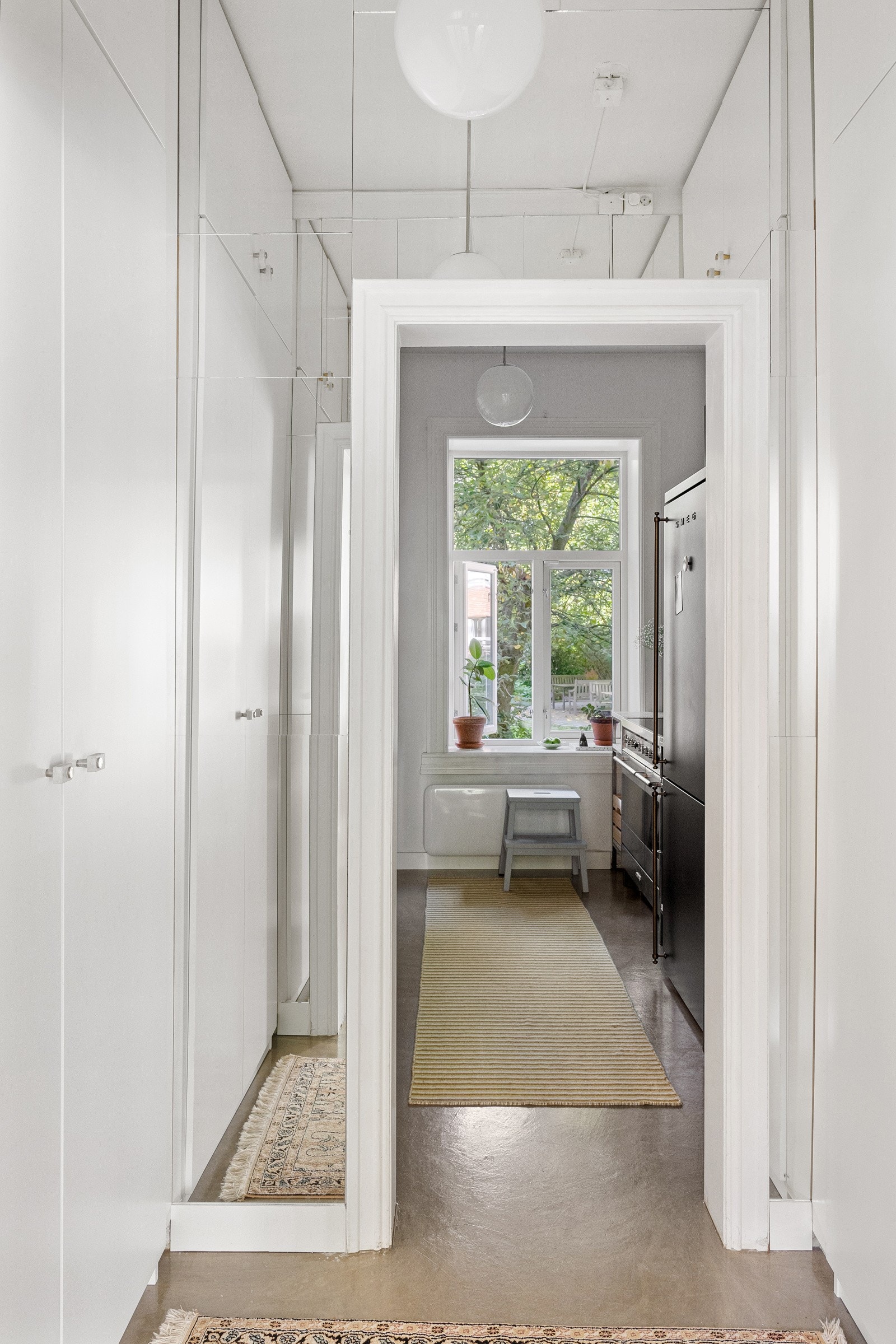 Mellomgang inn til kjøkkenet har garderobeskap på begge sider. Galleribilde