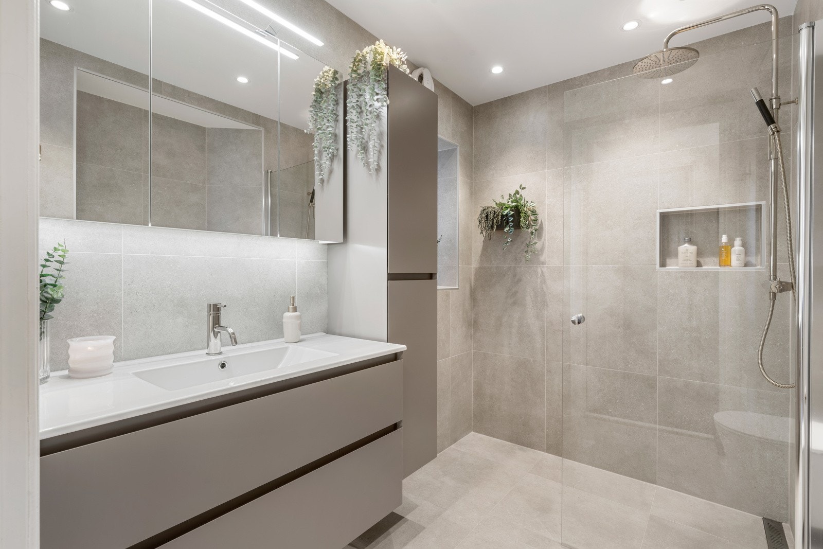 Like ved entréen ligger badet, som er nytt og lekkert med keramiske fliser på gulv og vegger Galleribilde
