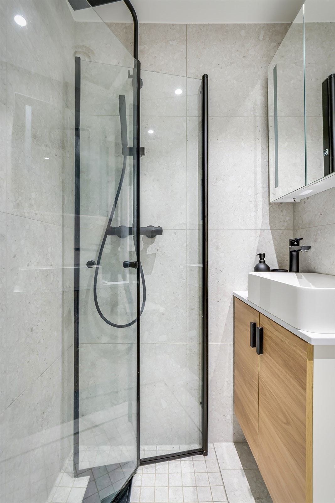 Badet består av veggmontert wc, dusjplass med inn-utadslående dusjvegger og servant med ettgreps blandebatteri. Galleribilde