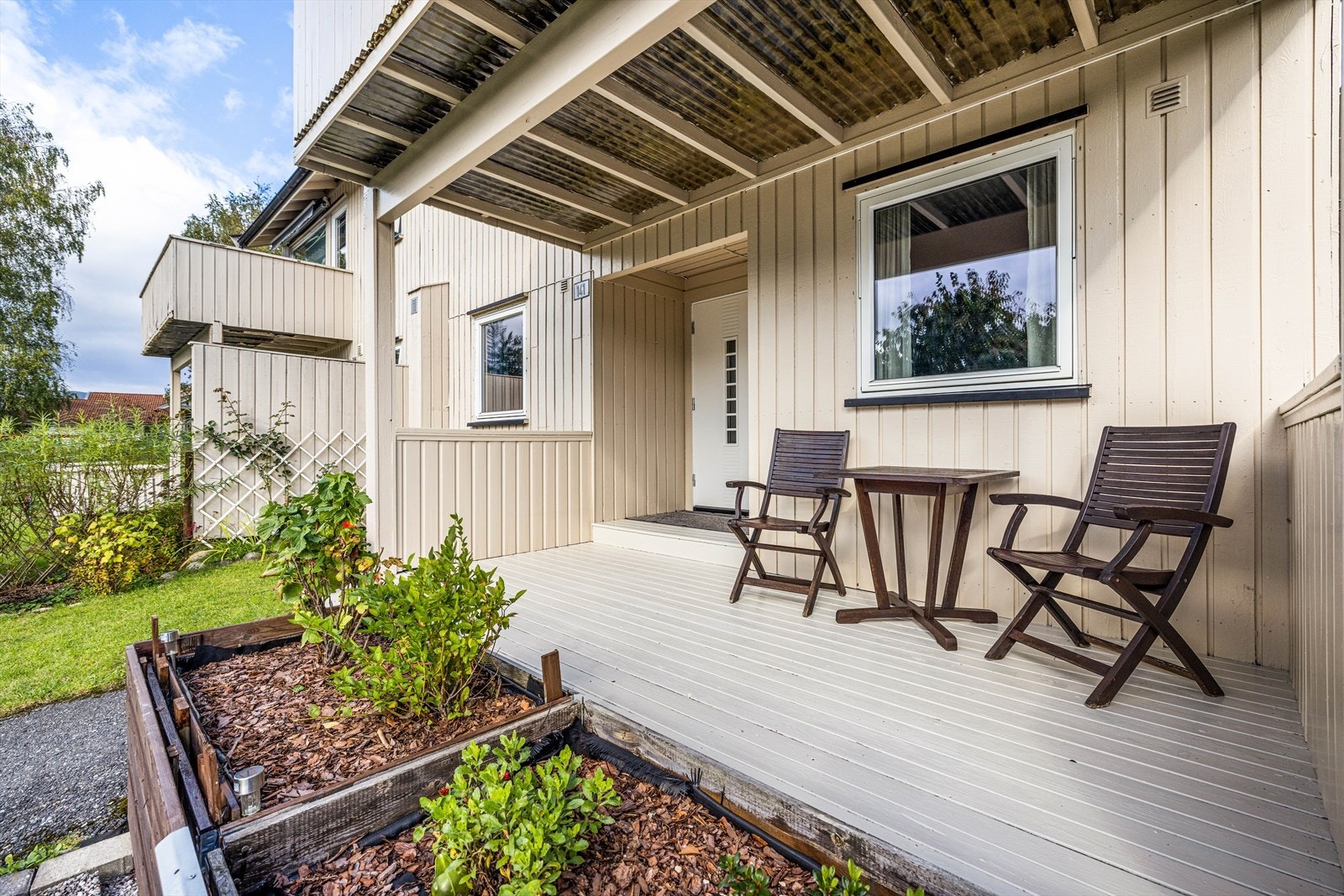 Ved inngangspartiet et det opparbeidet en flott uteplass med terrasse på 11 kvm og blomsterkasser. Galleribilde