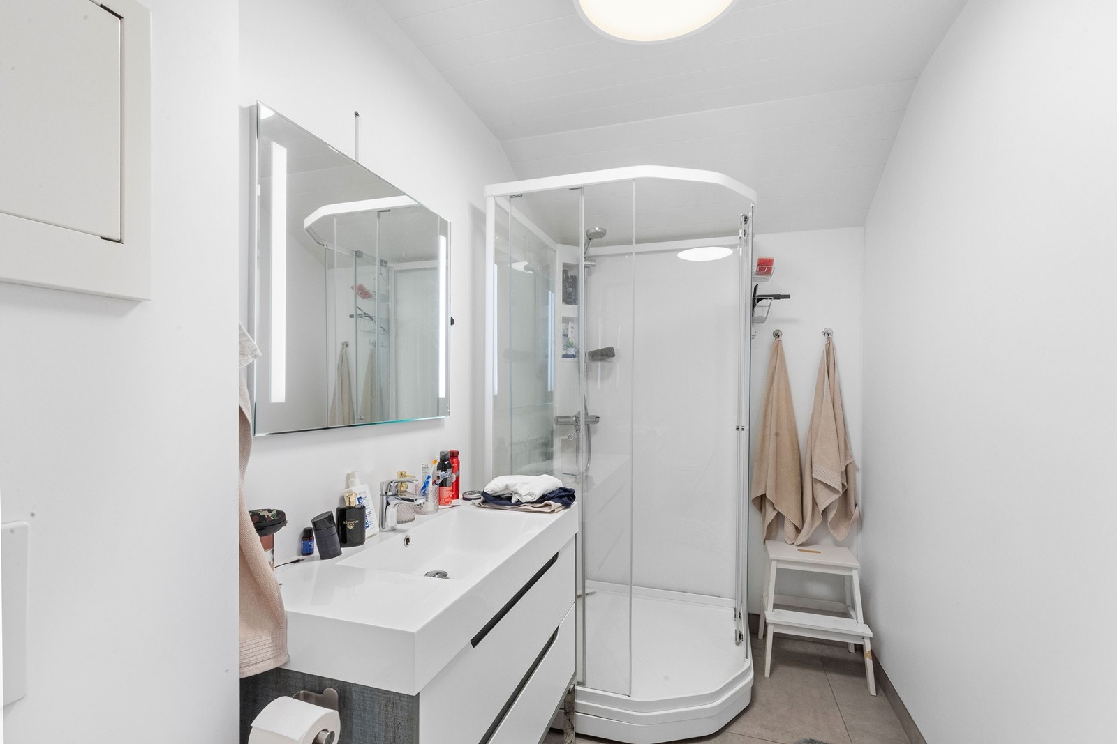 Bad på loft som inneholder wc, servant med underskuffer og dusjkabinett Galleribilde