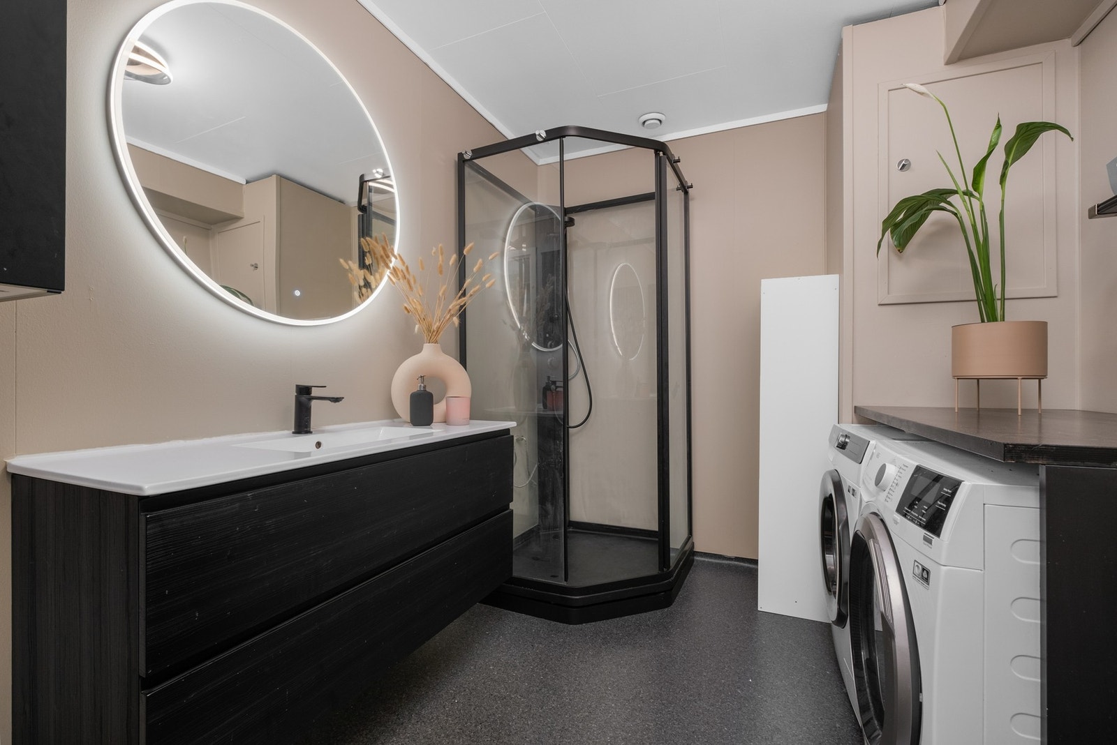 Badet er utstyrt med opplegg for vaskemaskin, varme i gulv og dusjkabinett Galleribilde