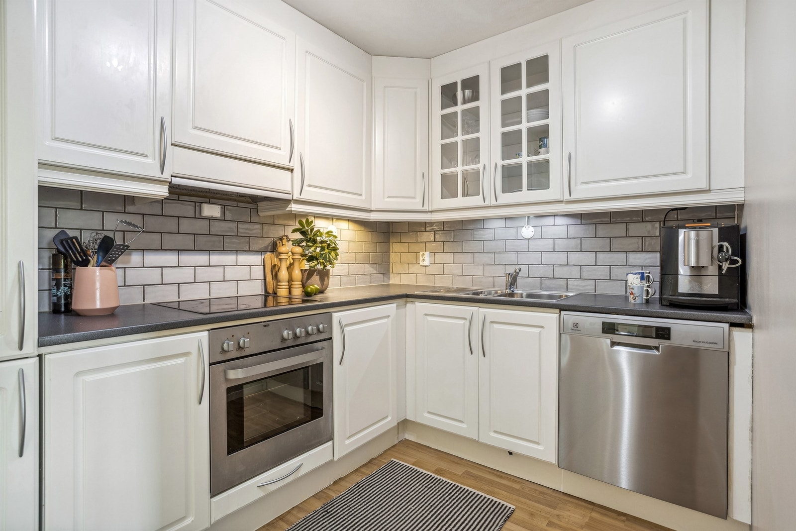 Kjøkkenet er utstyrt med stekeovn, platetopp, oppvaskmaskin samt kjøleskap med frys. Det er godt med skapplass og fine fliser mellom benkeplate og overskap. Galleribilde