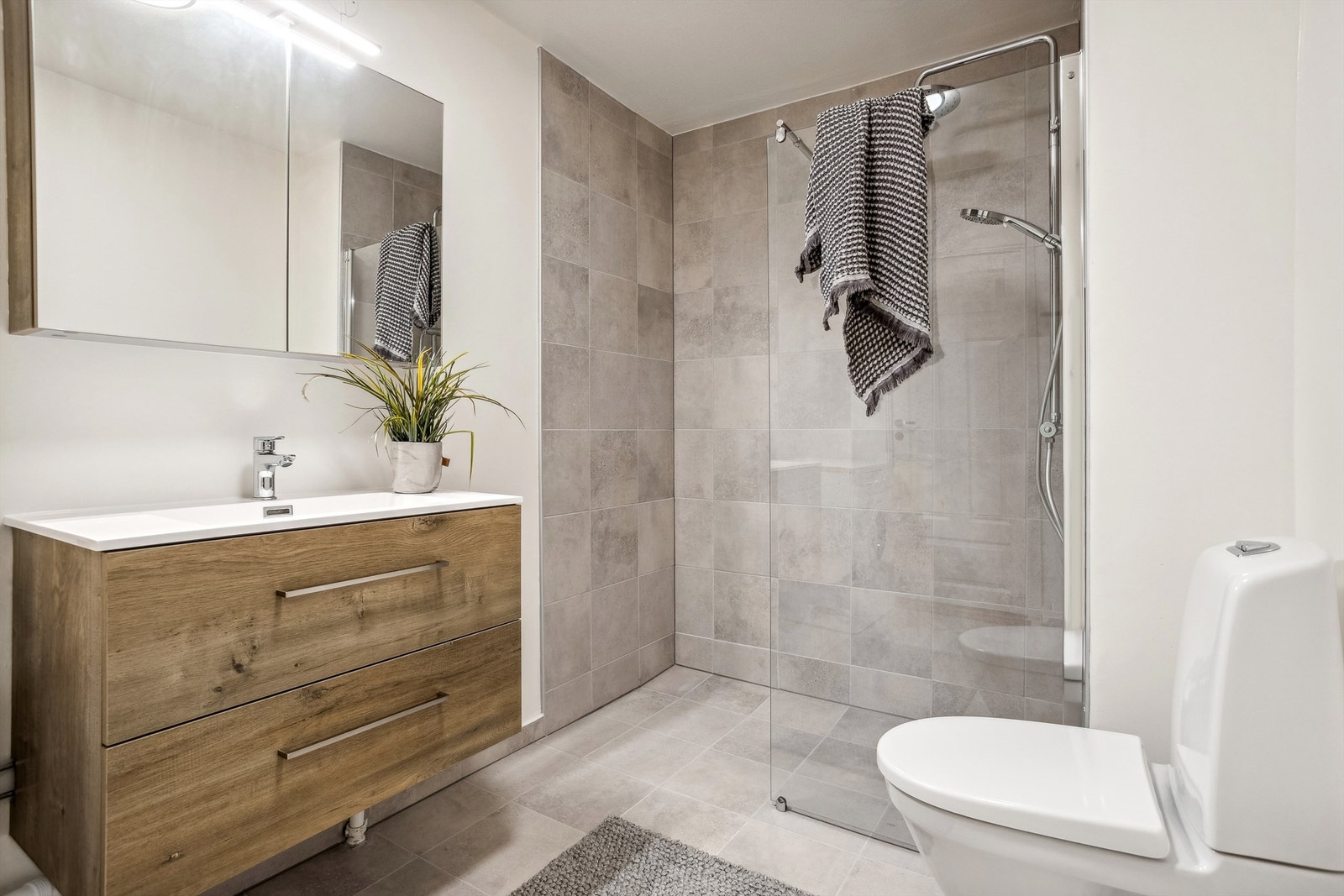 Lekkert og moderne bad som ble oppgradert 2024. Vegghengt servantinnredning med skuffer og stor dusjnisje med glassvegg. Galleribilde