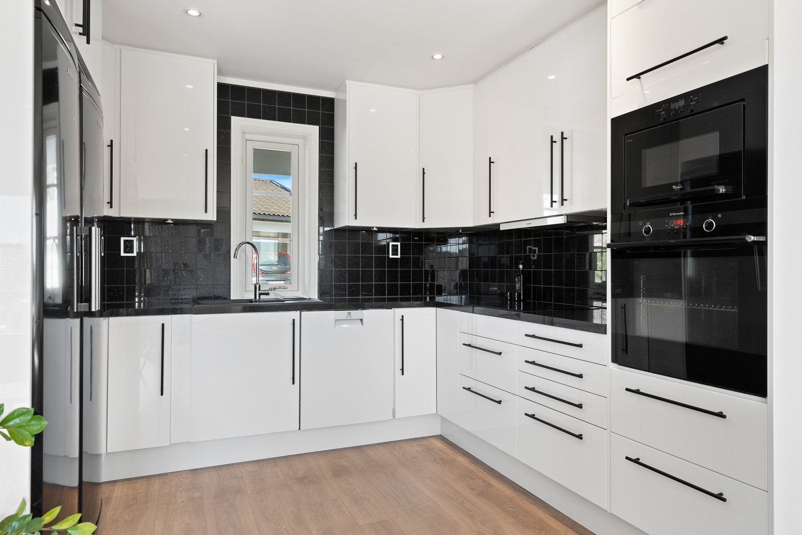 Kjøkkenet har takhøy innredning og integrerte hvitevarer Galleribilde