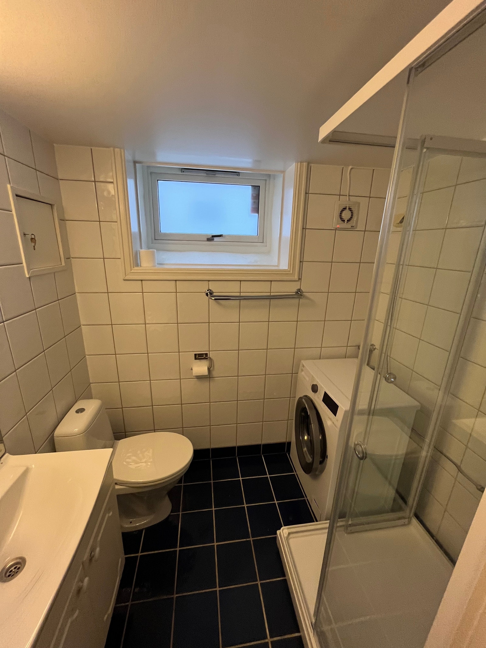 Flislagt dusjbad med vaskemaskin installert. Galleribilde