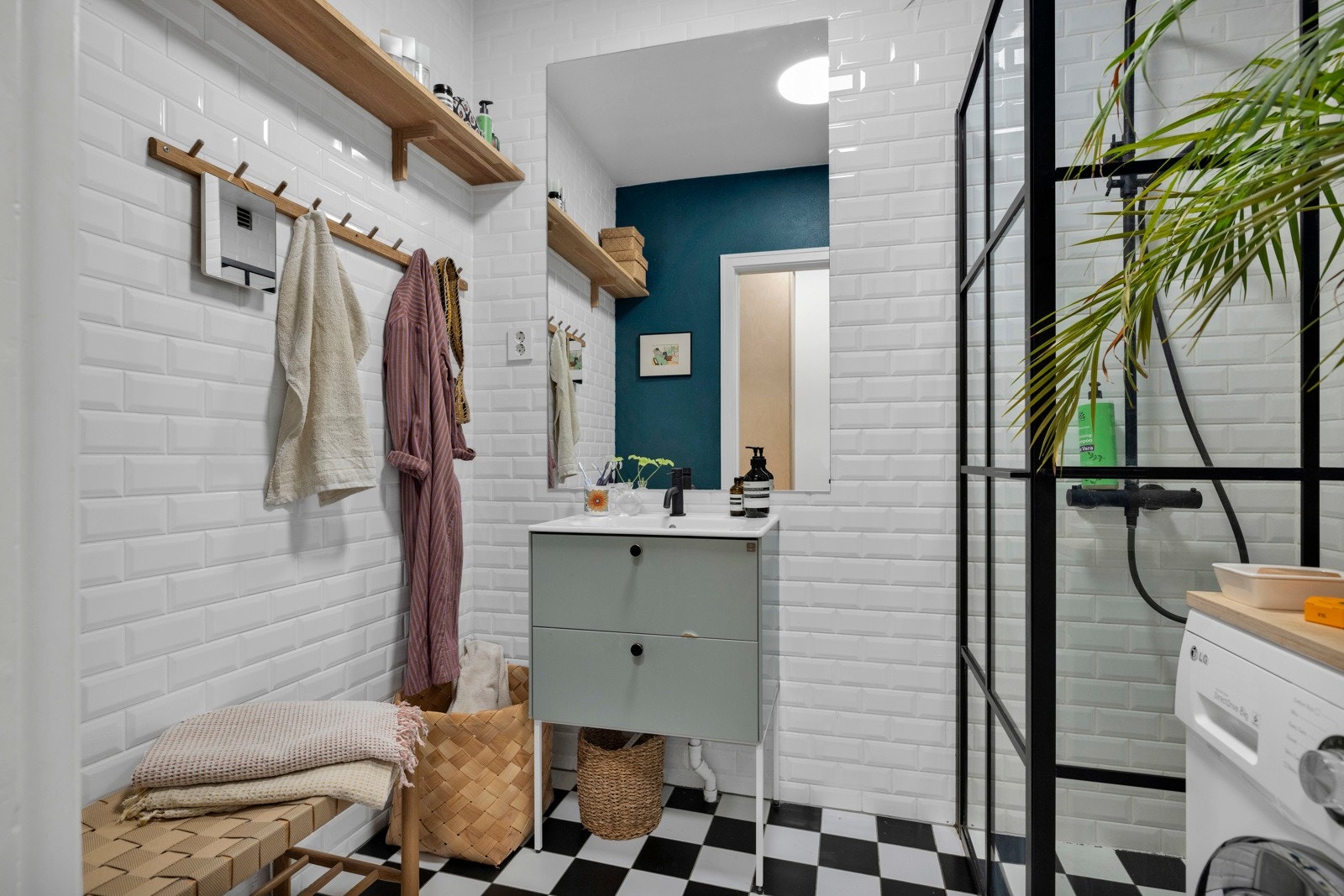 Badet har flislagte overflater, gulvvarme, pen innredning og opplegg for vaskemaskin. Galleribilde