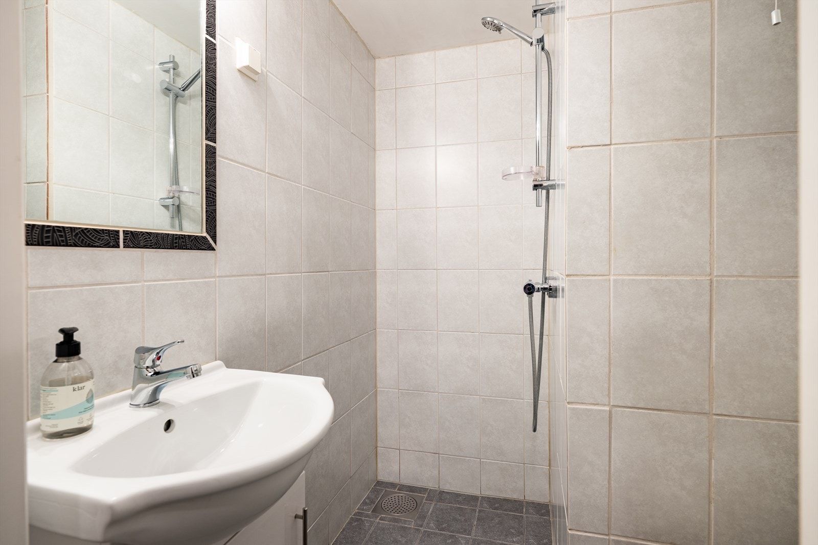 Badet har flis på vegger og gulv. Galleribilde