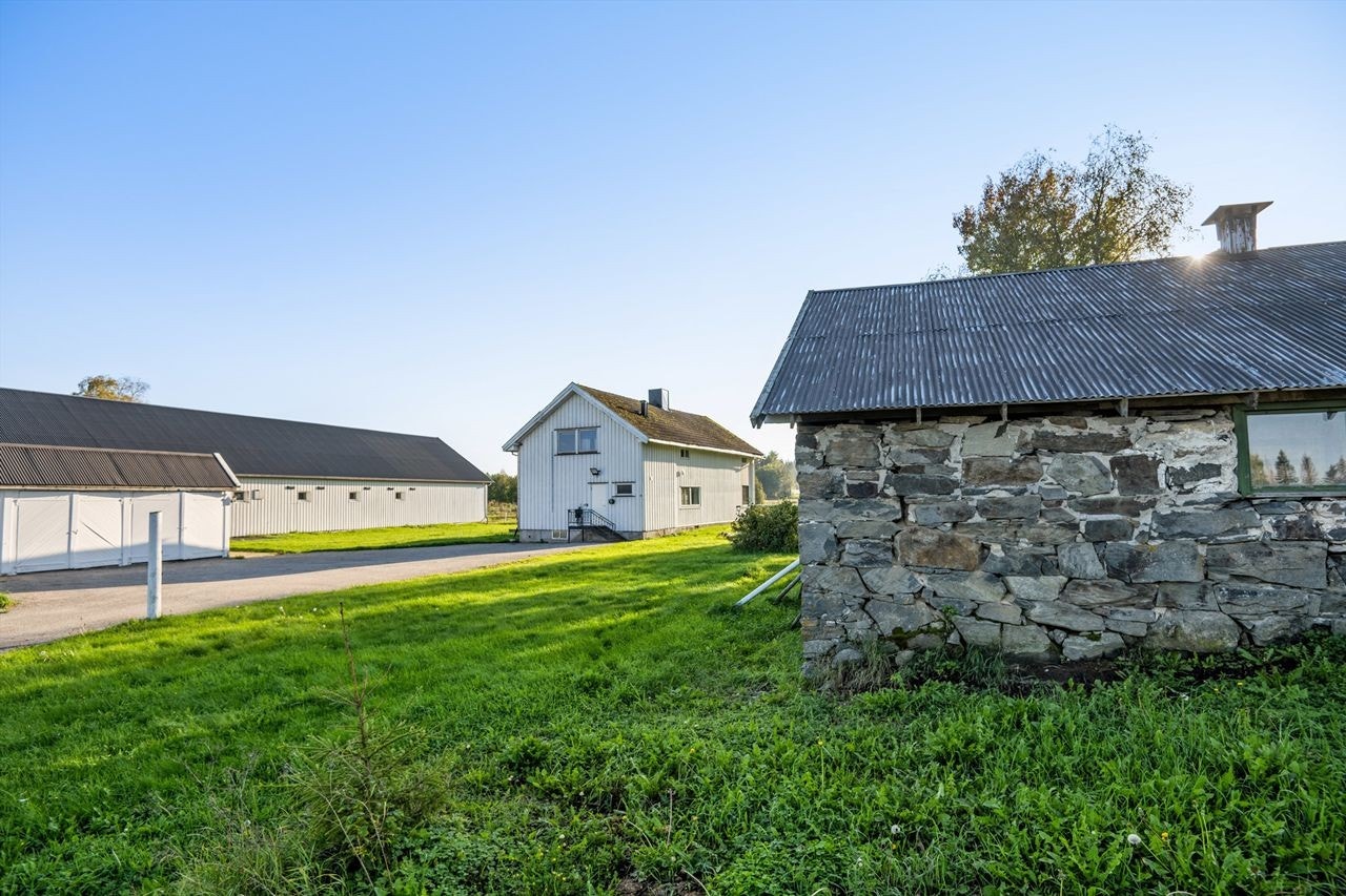 Tun og bygninger med det gamle steinfjøset i forgrunnen Galleribilde