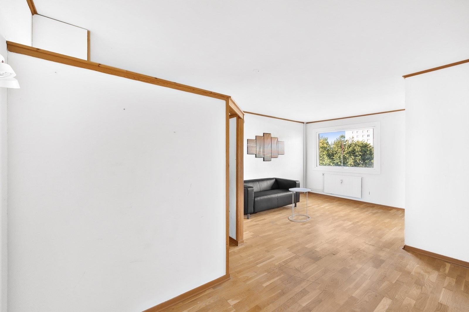 Leiligheten har en lys og romslig stue med store vindusflater. Her er det satt opp vegger for sovealkove Galleribilde