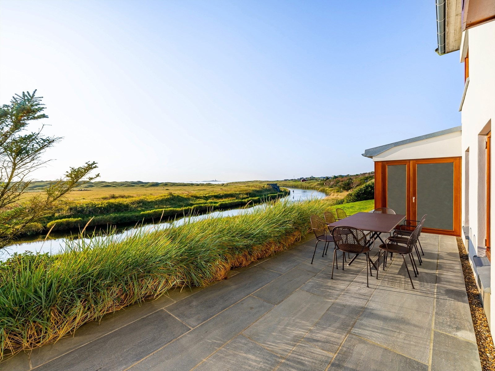 Kanskje går tankene til Danmark, hvor stråene vaier i vinden, sanddynene bølger og sola treffer den kritthvite muren. Men adressen er Selevegen 202, og du befinner deg i en fritidsbolig helt ulik alt annet du ser rundt deg. Galleribilde