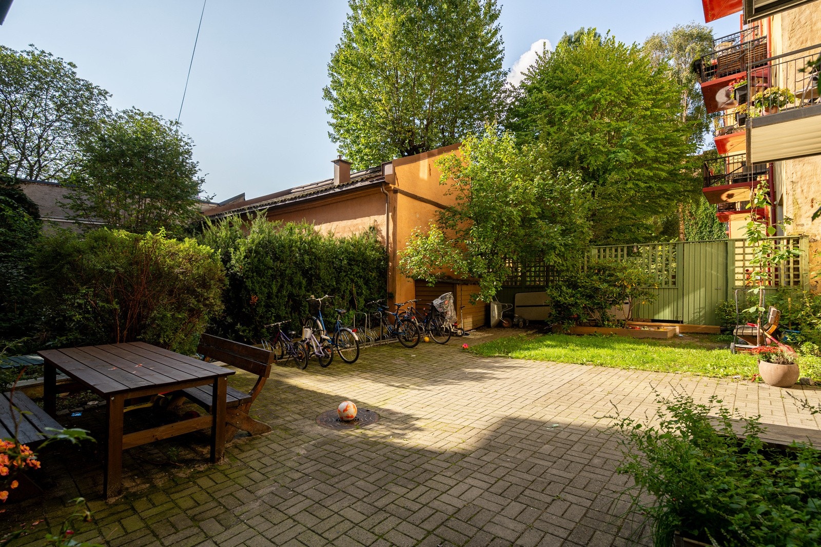 Borettslagets bakgård med sittegruppe, plantekasser og sykkelstativ. Galleribilde