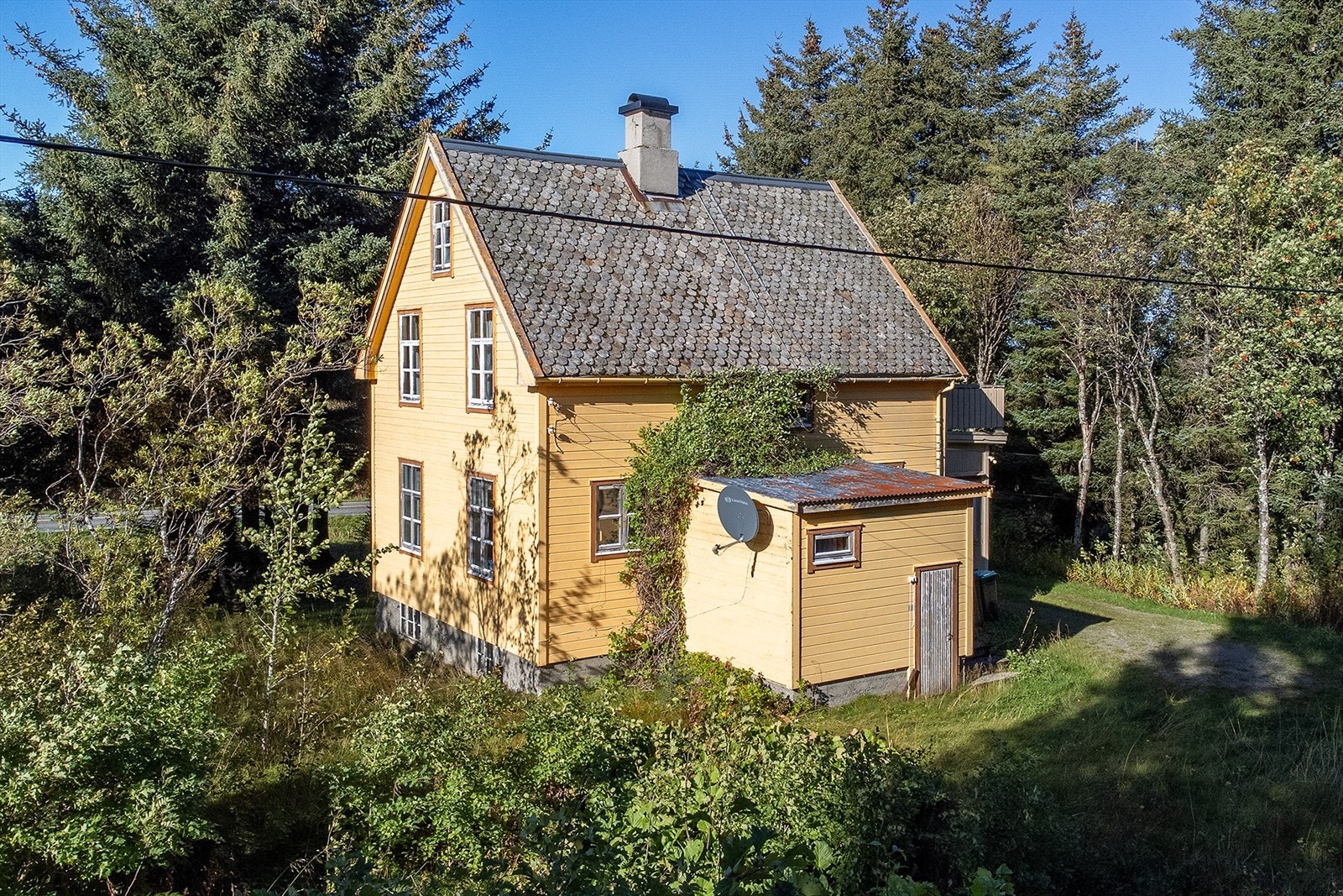 Dronefoto med fasade mot øst. Mindre utbygg fra 80-tallet med inngang og bad Galleribilde