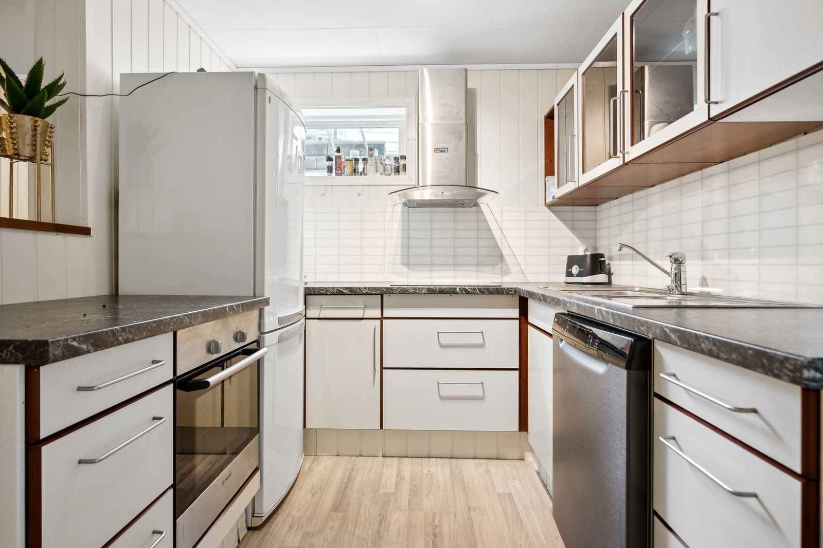 Kjøkkeninnredningen har lyse fronter mørk laminert benkeplate. Innredningen har avsatt plass til hvitevarer som stekeovn, oppvaskmaskin og kjøleskap. Galleribilde