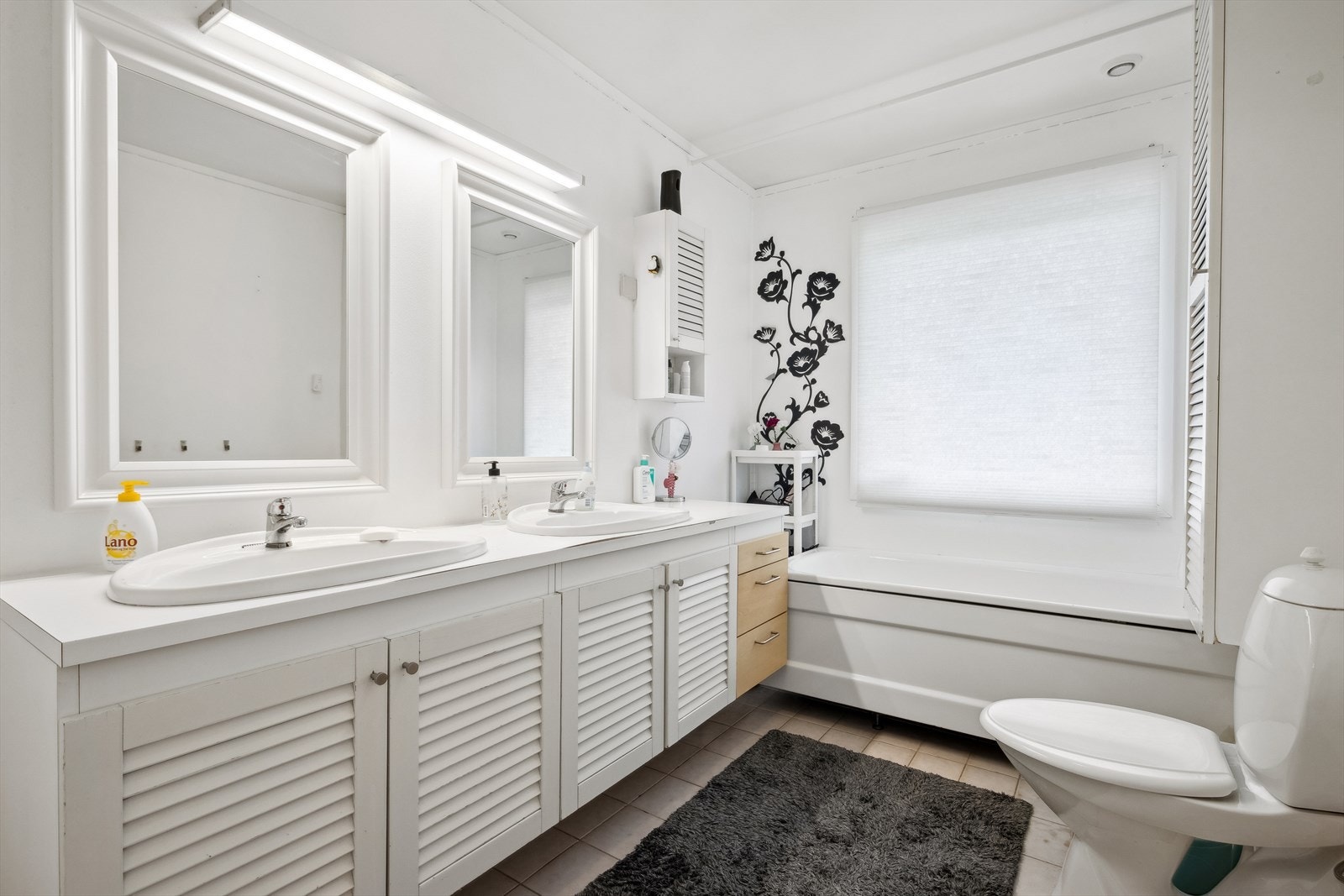 Badet er innredet med dobbel servant på seksjon, badekar og toalett. Galleribilde