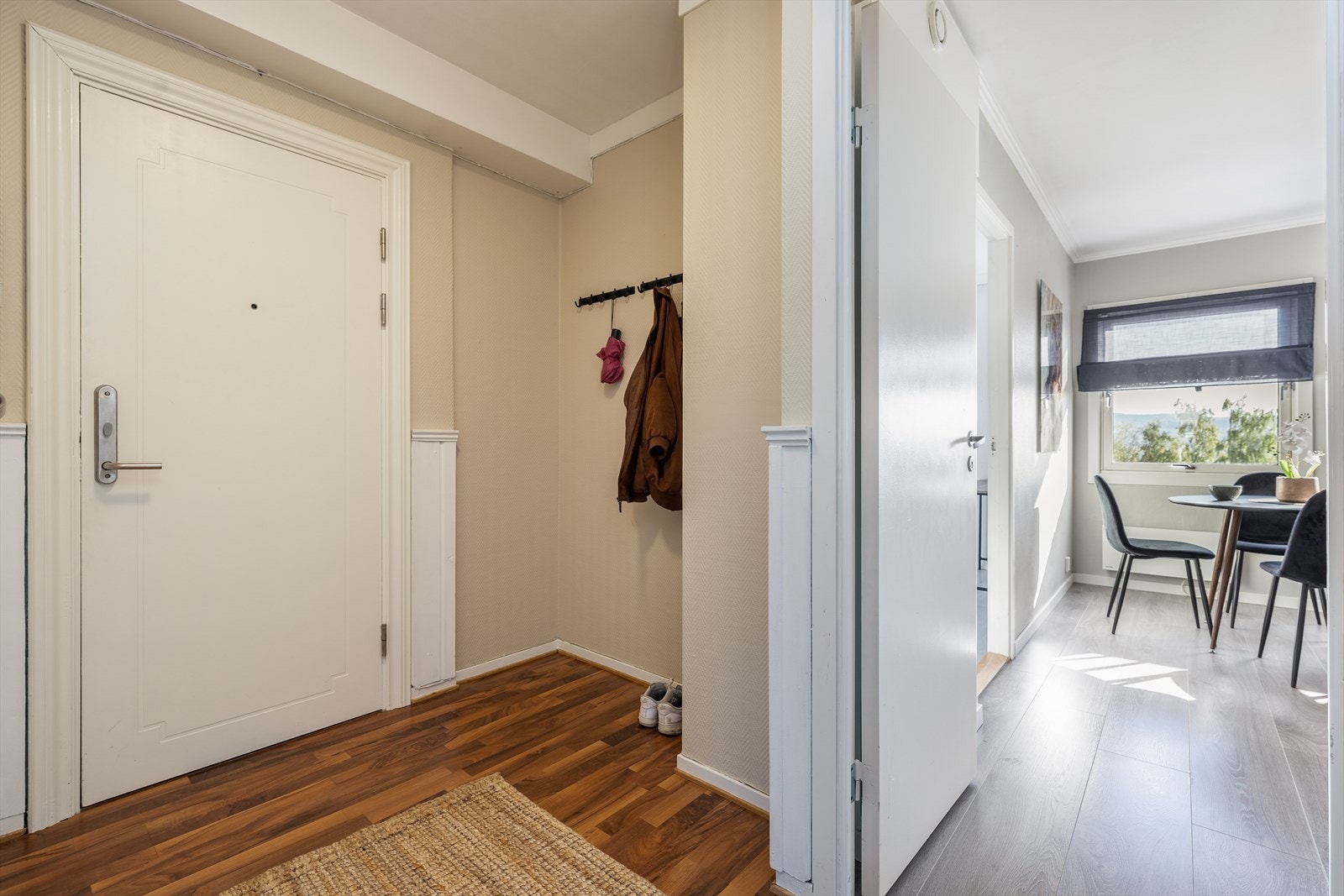 Trivelig entré som ønsker velkommen inn! Her er det plass til å sette fra seg sko, samt henge fra seg yttertøyet på veggmontert knaggrekke. Overflater i entré består av laminat på gulv, malt brystningspanel og malte veggflater, samt malt puss i tak. Galleribilde