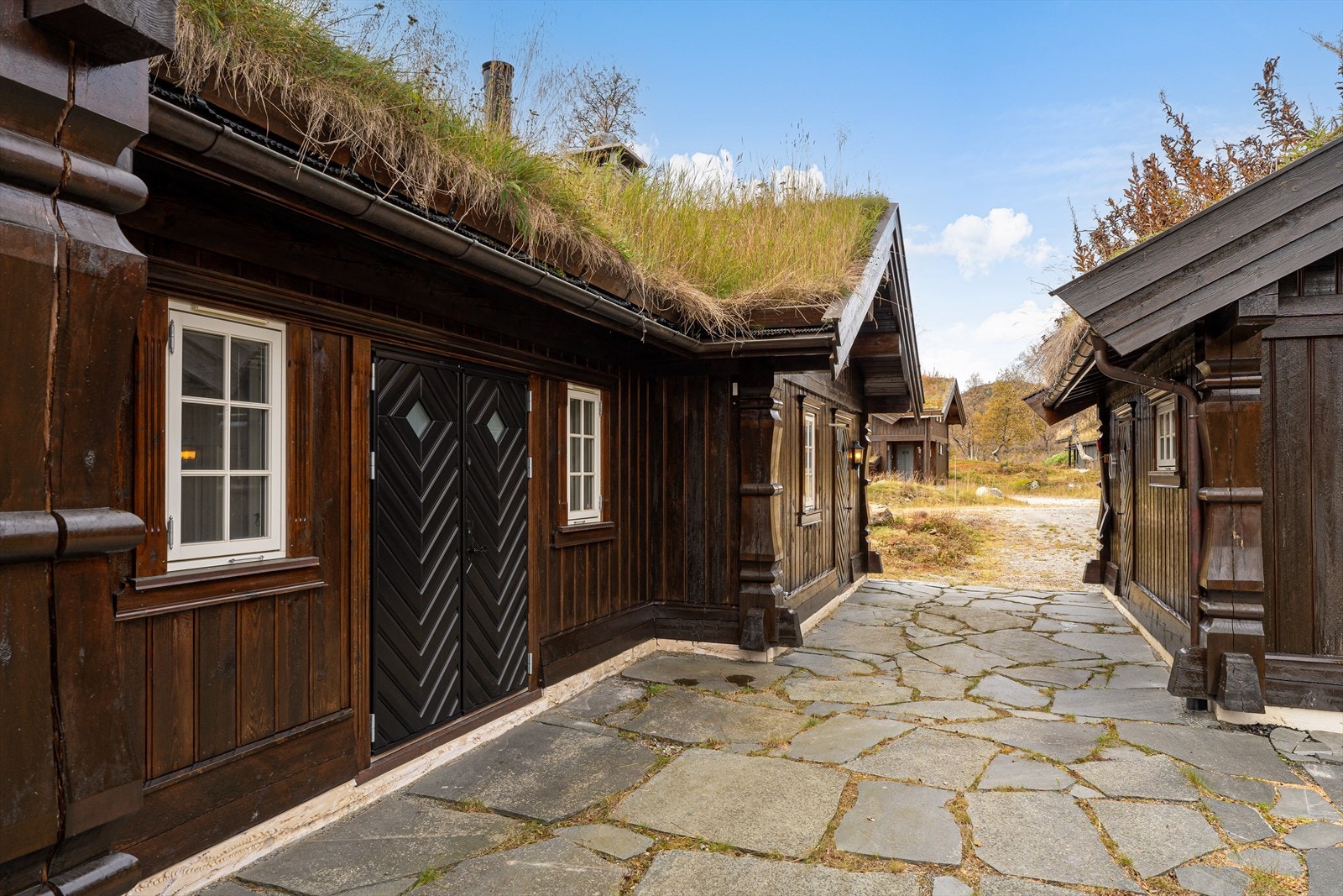 Skiferbelagt uteområde knytter hytten og garasje som et tun Galleribilde