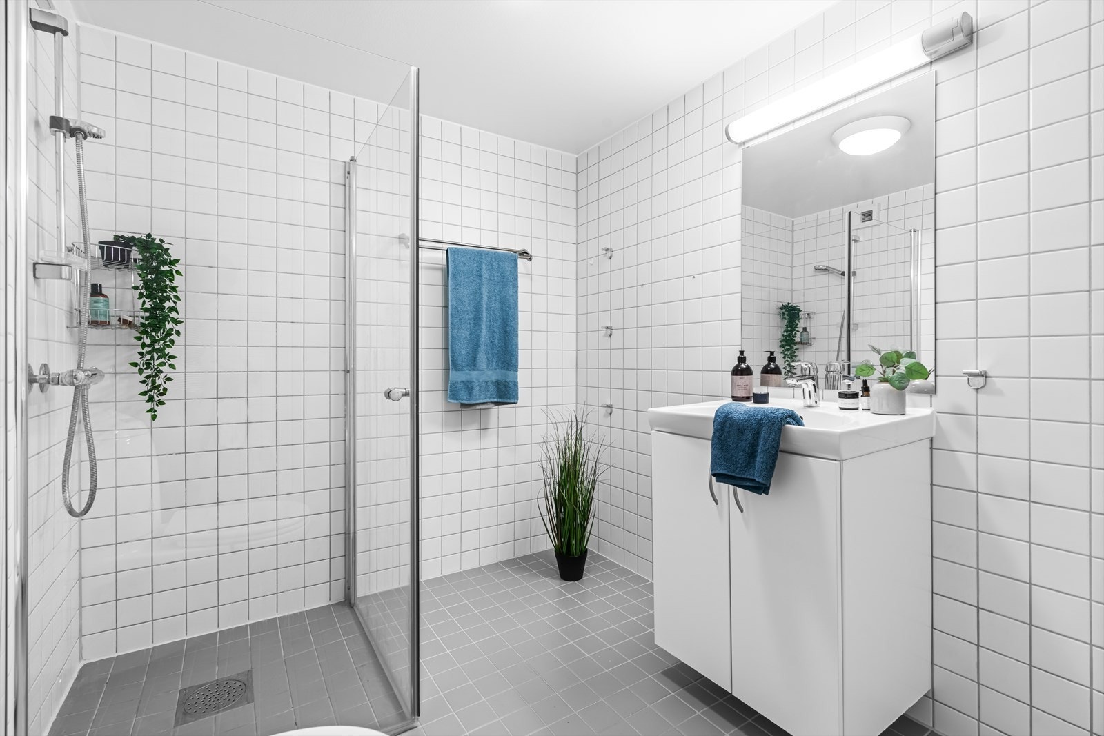 Flislagt bad med varmekabler. Baderommet er utstyrt med innredning med nedfelt servant og dusj med glassdører. Galleribilde