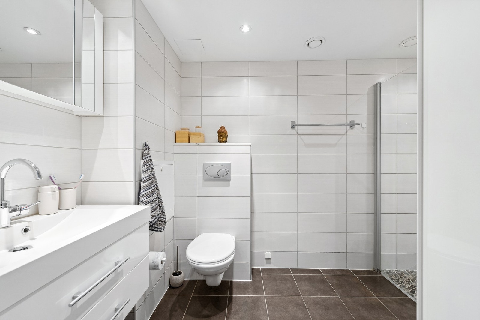 Delikat, helfliset bad fra 2009 med servant, vegghengt toalett, dusjhjørne og opplegg for vaskemaskin Galleribilde