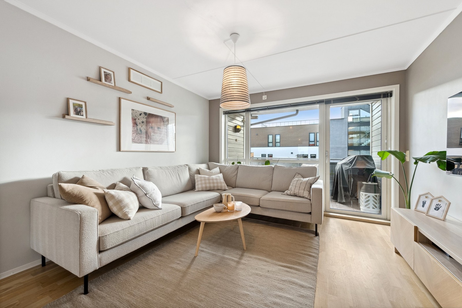 Lys og pen stue malt i en behagelig beigetone og parkett på gulv Galleribilde