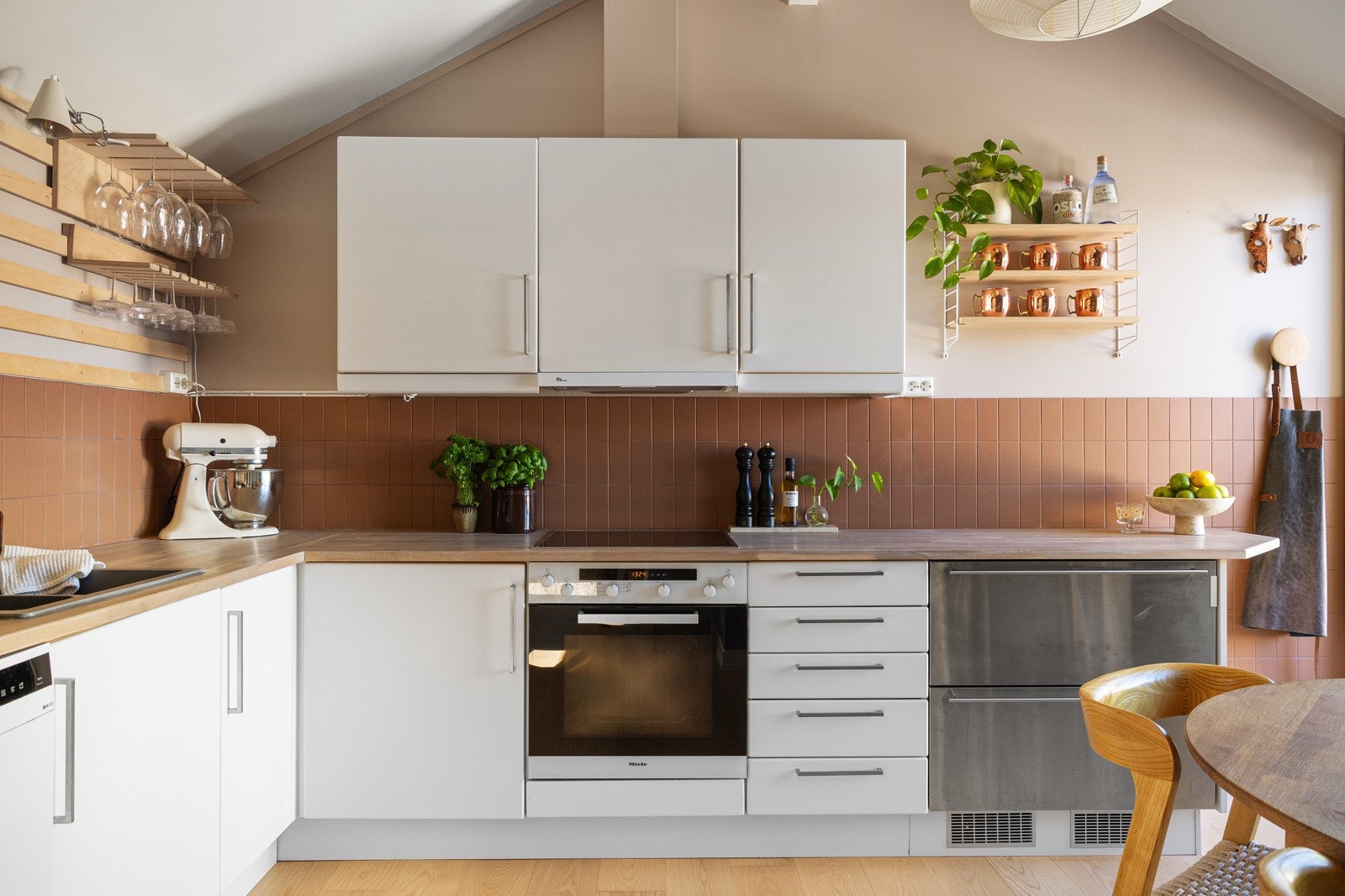 Kjøkken med glatte fronter, heltre benkeplate, og integrerte hvitevarer. Galleribilde