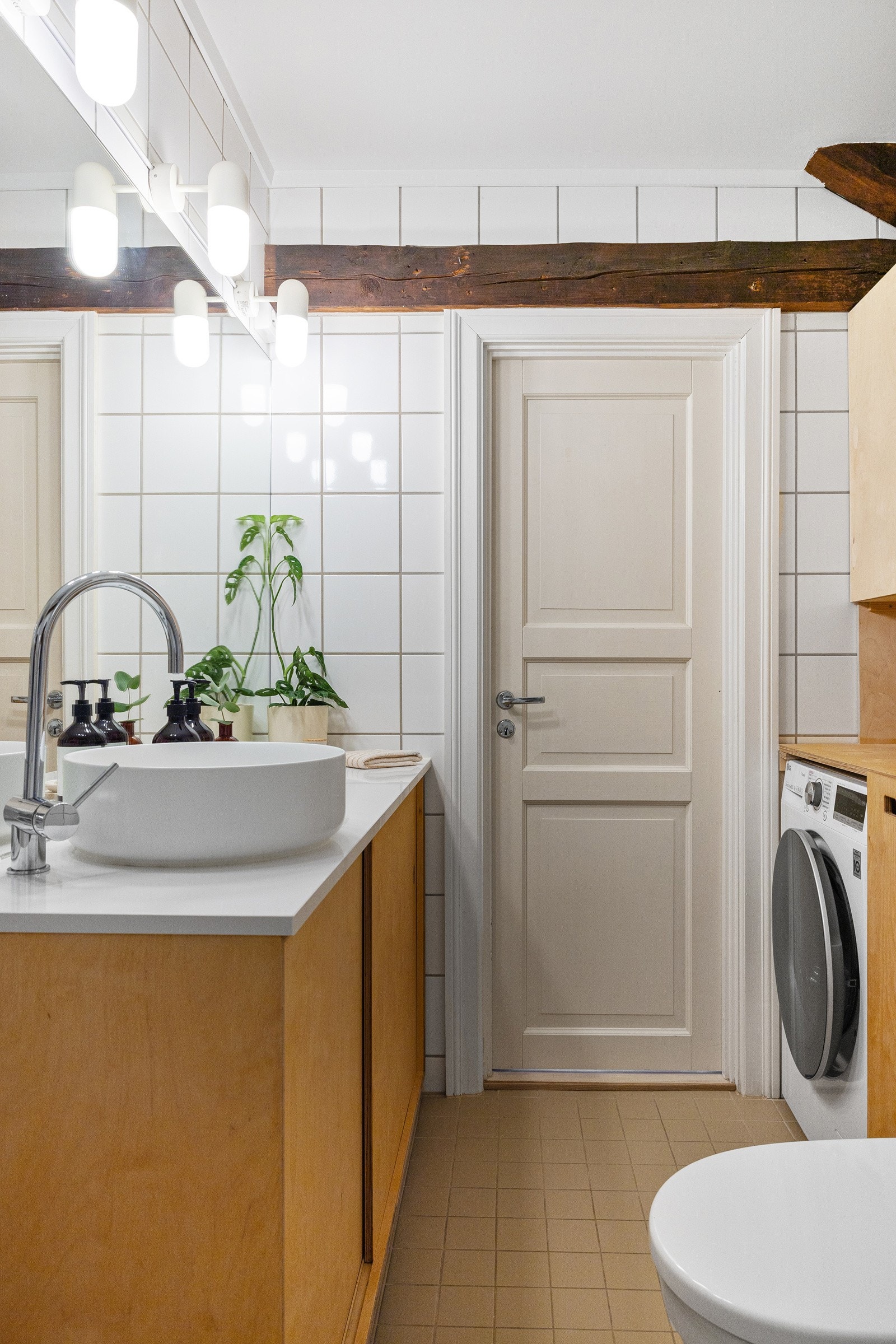 Plassbygd innredning med servant, innmurt badekar, regndusj og opplegg for vaskemaskin. Galleribilde