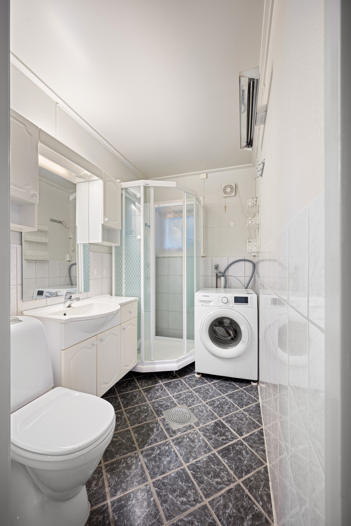 Badet har varme i flislagt gulv, dusjkabinett og opplegg for vaskemaskin Galleribilde