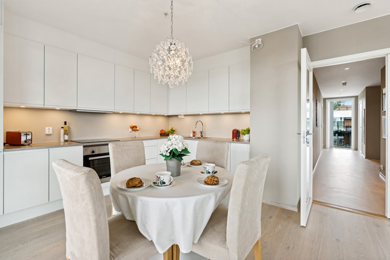 Lekkert HTH kjøkken med glatte fronter i lys utførelse og benkeplate i laminat med nedfelt kum i stål. Galleribilde