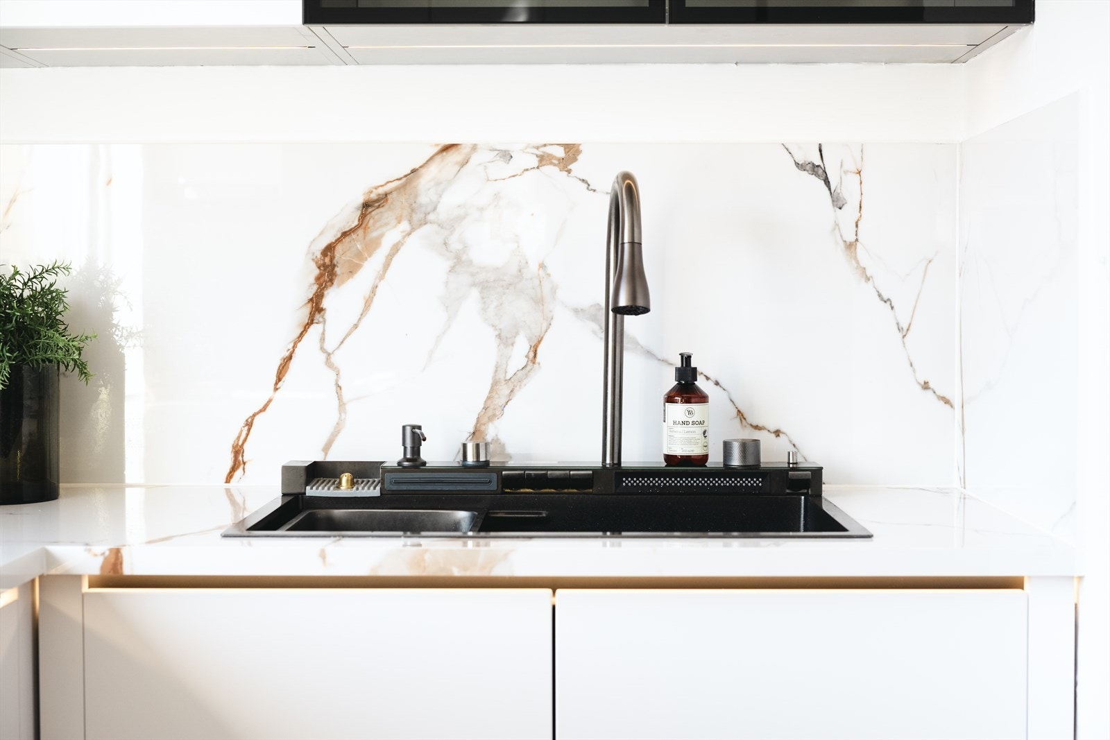 Kjøkkenet har blant annet benkeplate av kompositt, glatte fronter og LED belysning Galleribilde