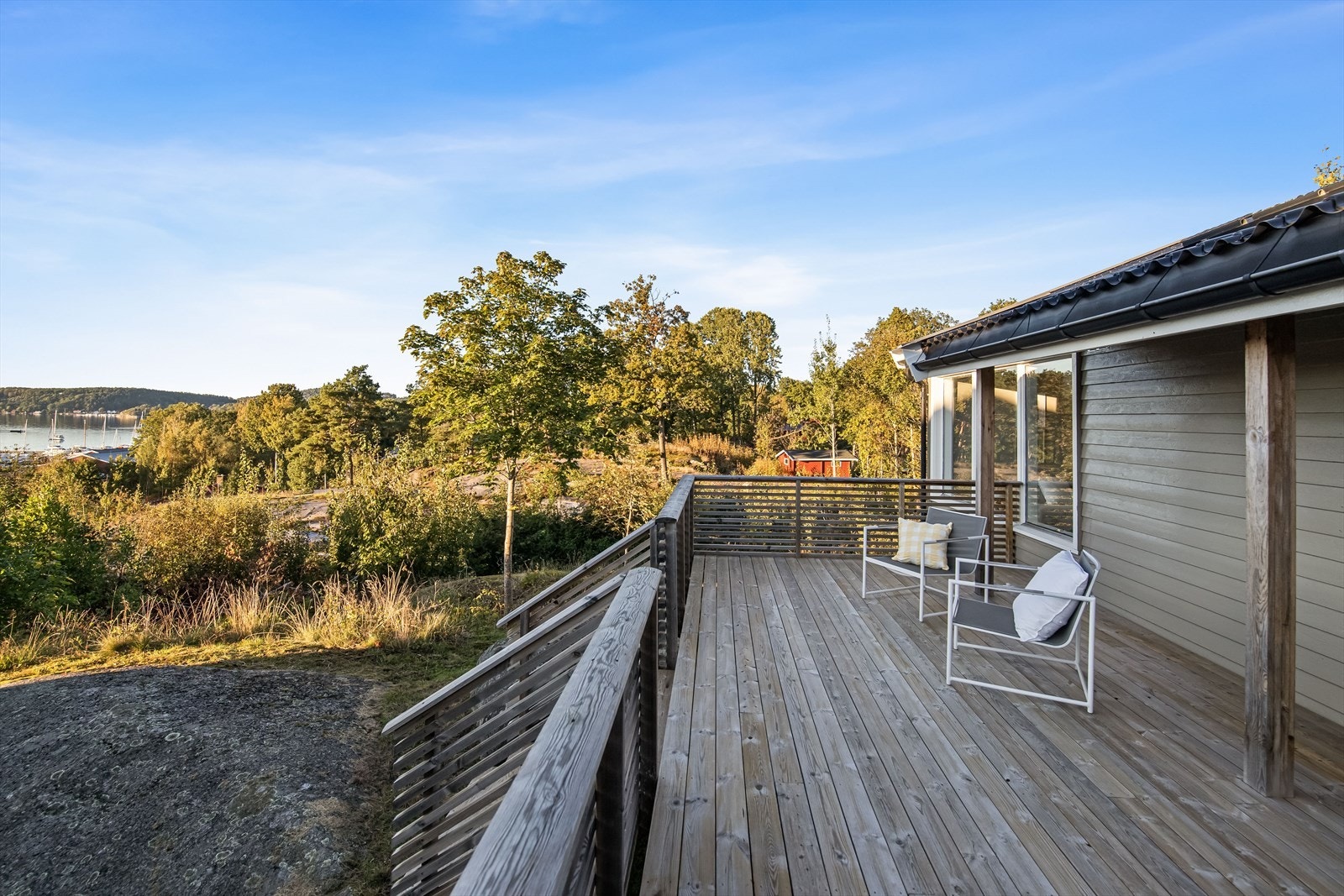 Terrassen er opparbeidet på dekke av tre og pent innrammet med rekkverk. Det er trapp ned til terreng. Galleribilde