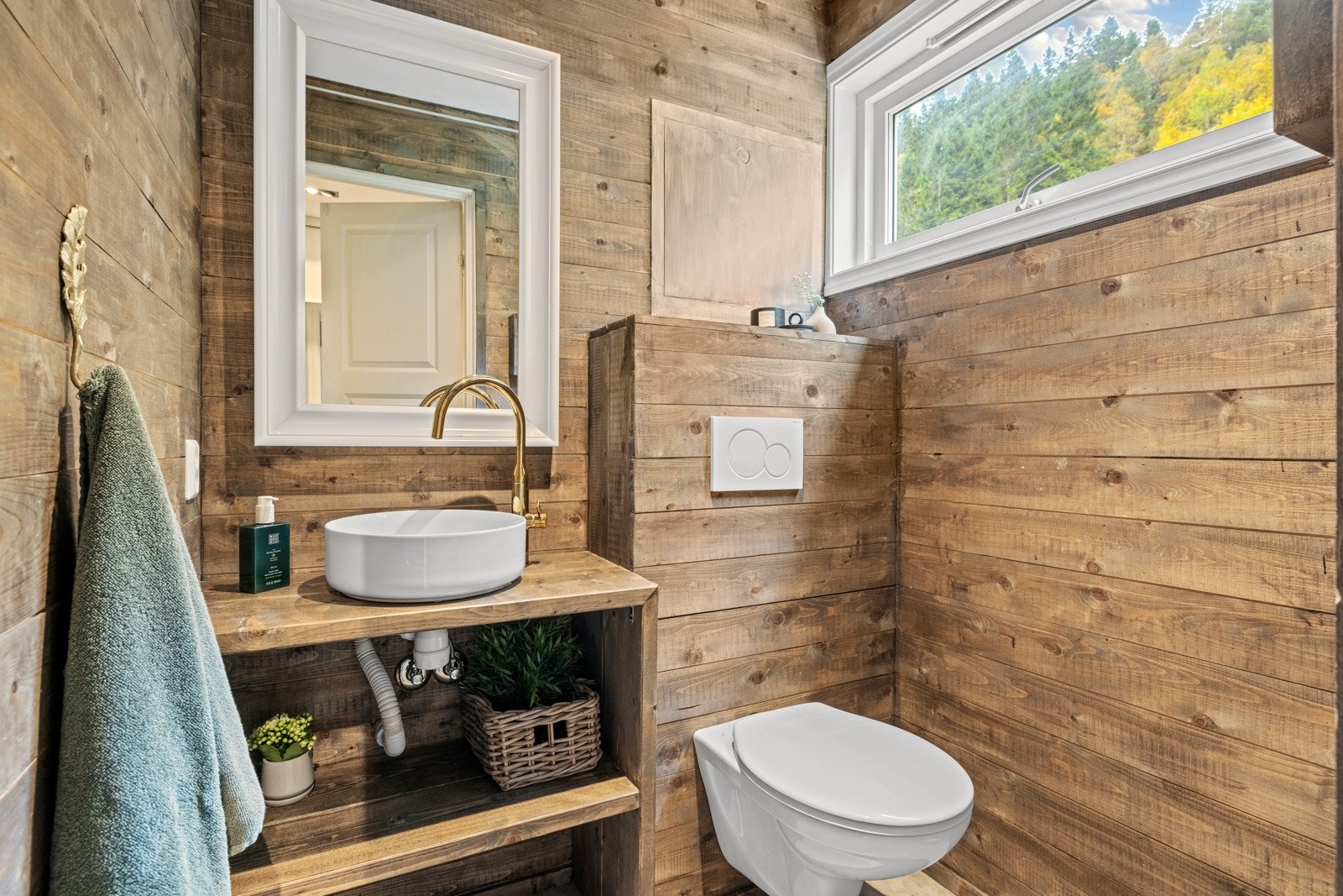 Toalettrom i 1. etasje med fliser på gulv og malt panel på vegger. Galleribilde