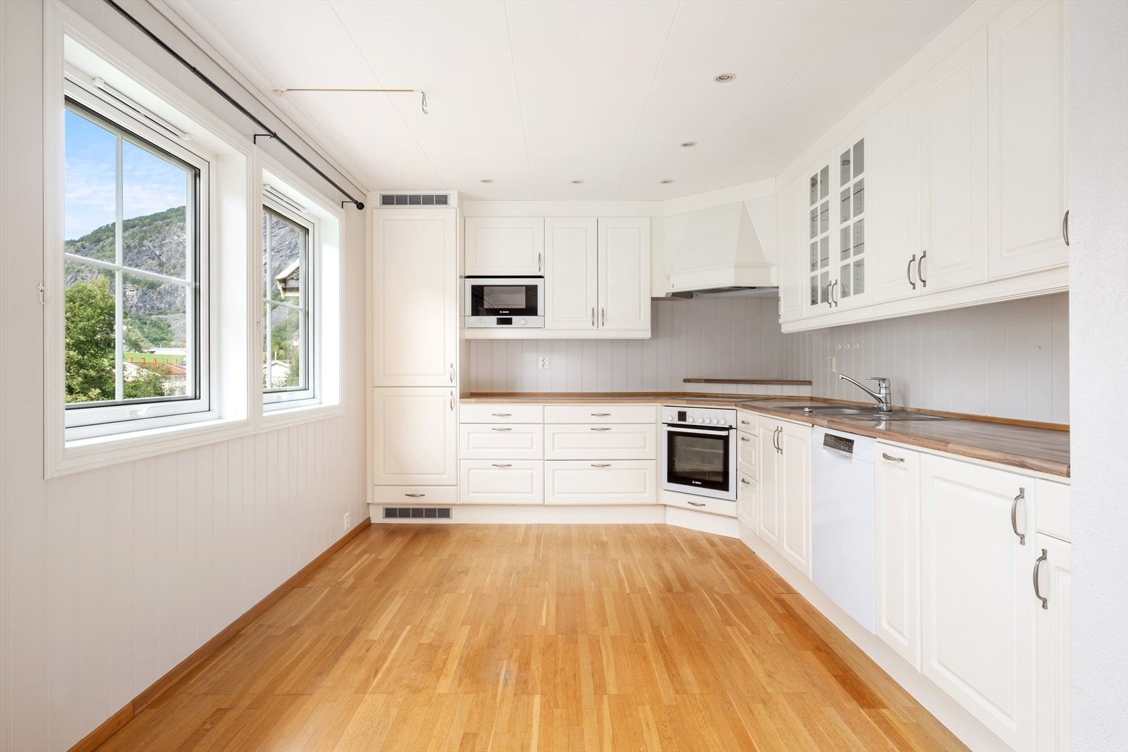 Kjøkendelen har lyse profilerte skåpfrontar og benkeplate av laminat. Galleribilde