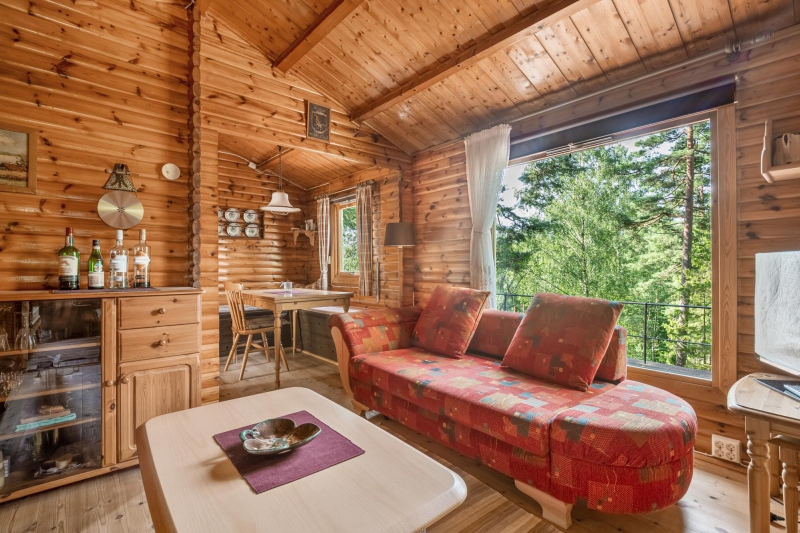 Stue med stort vindu som gir rikelig med naturlig lys og flott grønn utsikt. Galleribilde