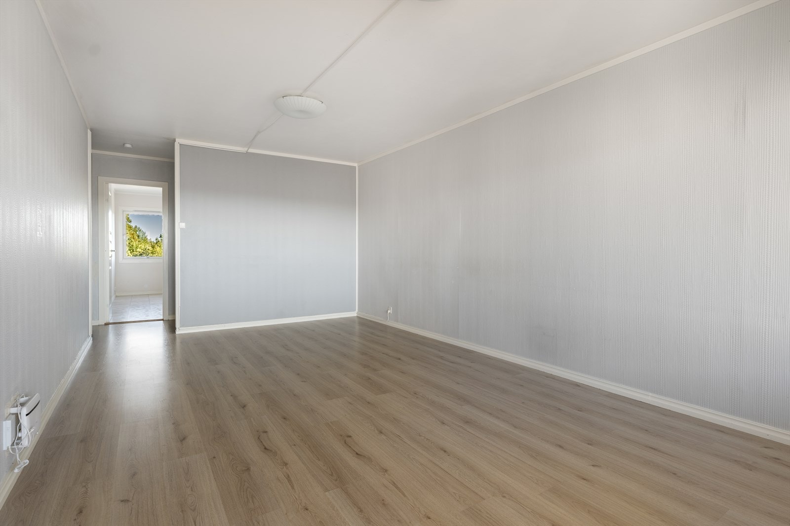 Stuen har god plass til sofa og mediemøblement. Kabel tv og internett er inkludert i felleskostnadene. I stuen er det laminat på gulv, malt tapet på vegger og malt pusset betong i tak. Galleribilde