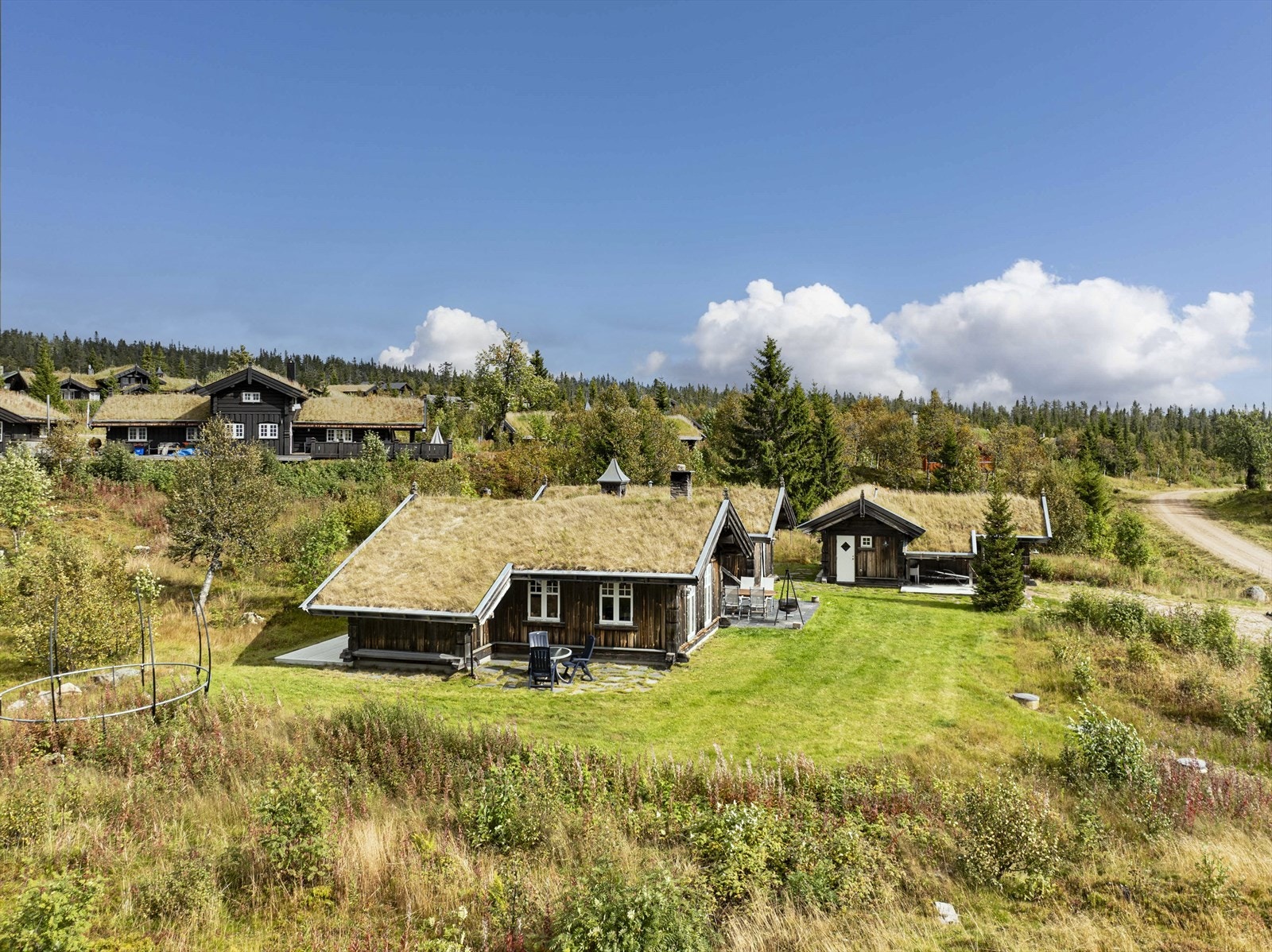 Eiendommen er pent opparbeidet med plen og noe naturtomt. Galleribilde