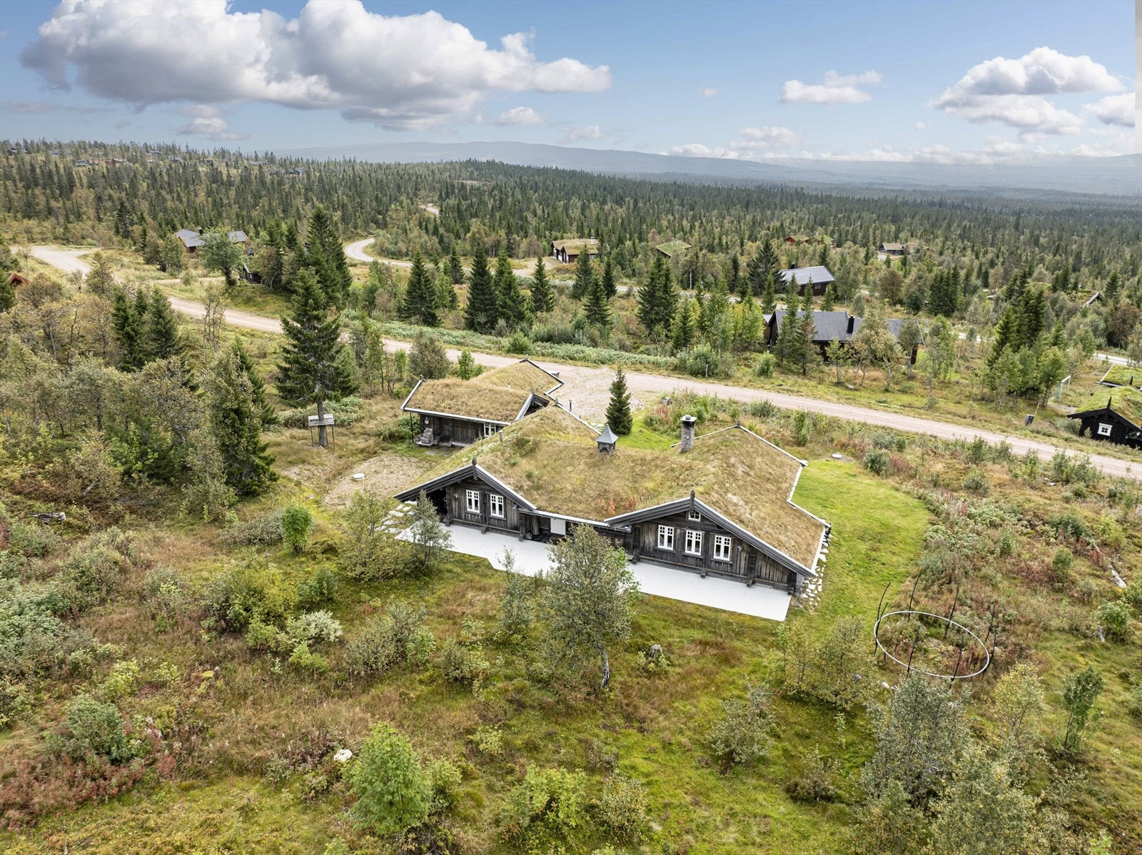 Nordvendt terrasse ved inngang på ca. 60 m², hvorav ca. 8 m² er oppført med skifer på støpt plate mot grunn og overbygget med tak. Galleribilde