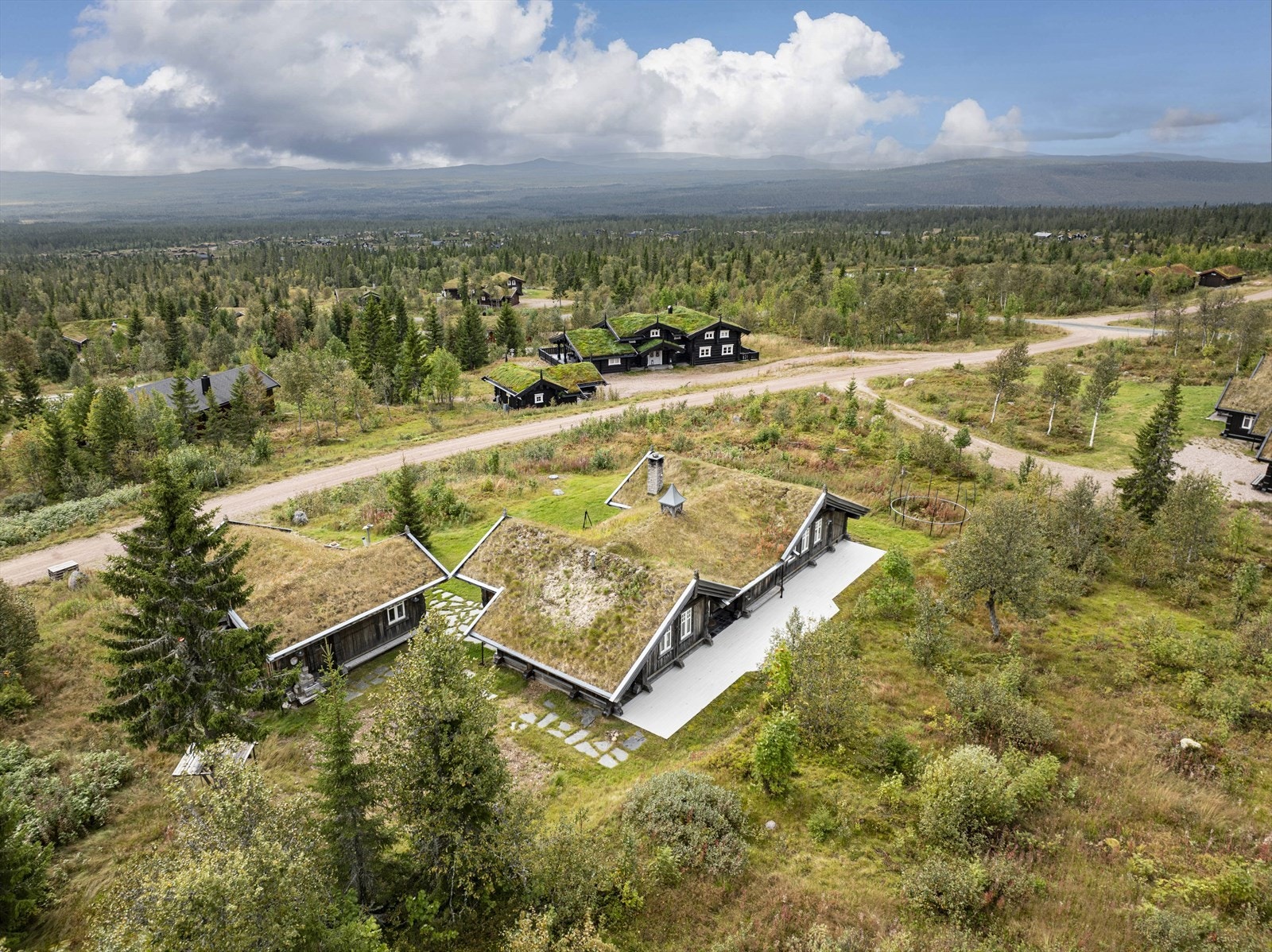 Hytta har terrasse ved inngang på ca. 60 m², hvorav ca. 8 m² er oppført med skifer på støpt plate mot grunn og overbygget med tak. Galleribilde