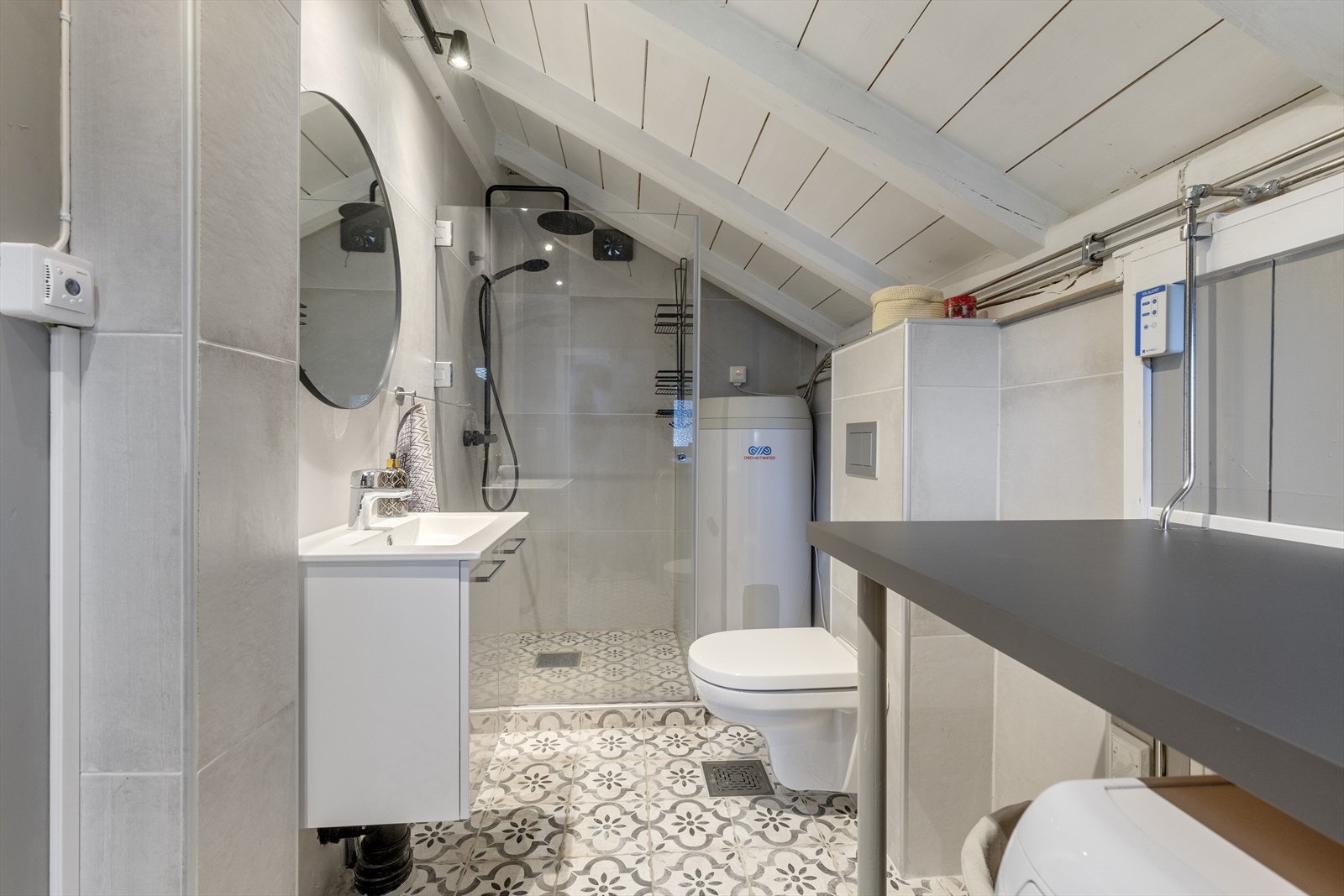 Bad 1 er innredet med servantskap med speil over heldekkende servant, dusjshjørne med regnfallsdusj, hånddusj og dører i glass. Det er flis på gulv med termostatstyrt varme, for det meste store flis på vegg og behandlet tre i himling. Galleribilde