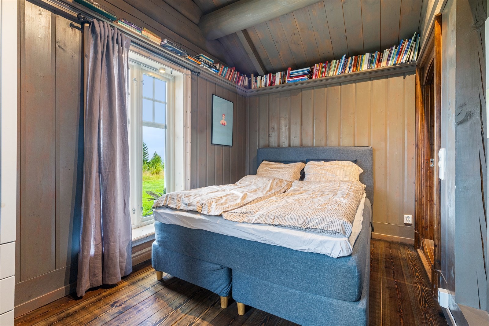 Hovedsoverommet er lunt og romslig med furugulv, malt trepanel på vegg med hyller for bøker, og trepanel med dimbare spotlights i himling. Galleribilde