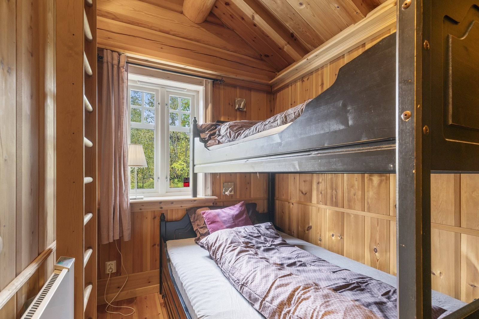 Soverom 2 har køyseng med 3 sengeplasser og hems for ekstra soveplasser eller lagring, beliggende i østenden av hytta. Vindu med utsyn mot nordvendt terrasse. Galleribilde
