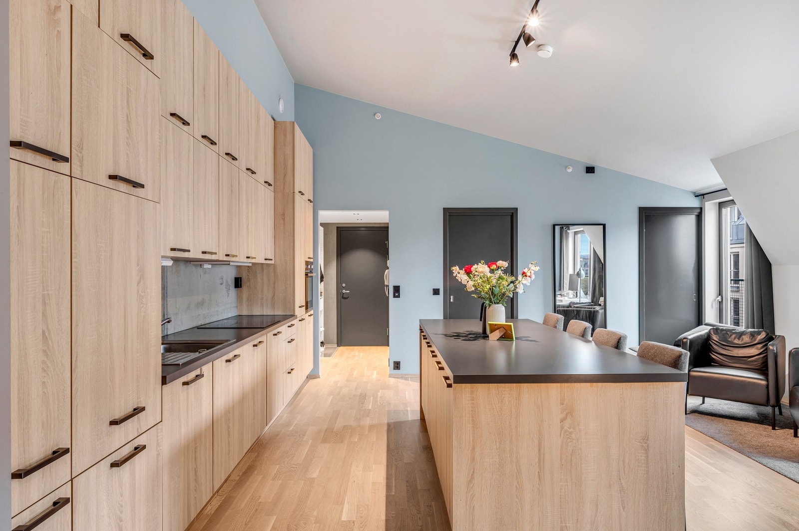 Kjøkkeninnredning og kjøkkenøy med plane fronter, folierte skrog og laminerte benkeplater. Galleribilde