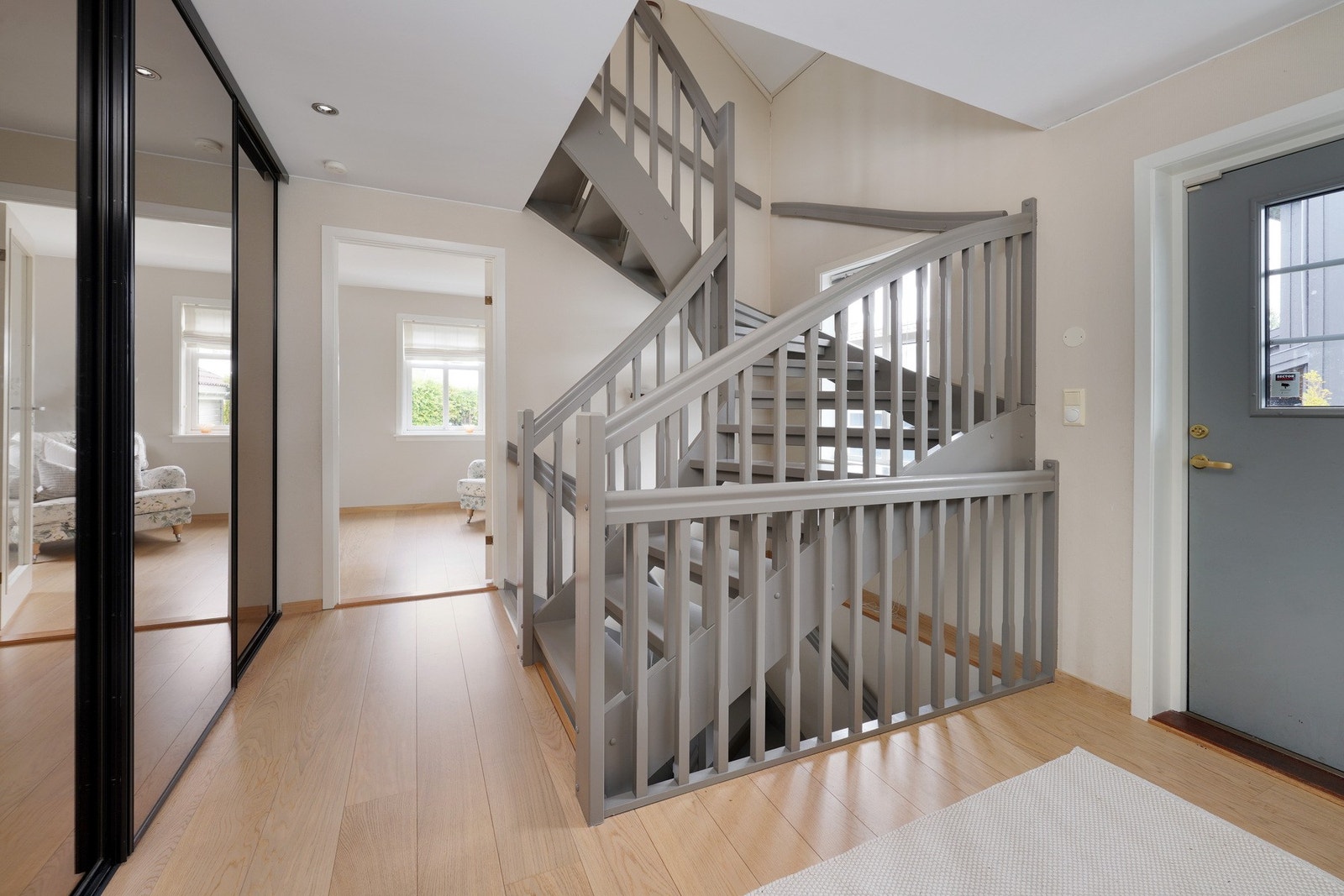 Det første man møter i huset er en romslig gang med stor skyvedørsgarderobe, samt pen, moderne trapp Galleribilde