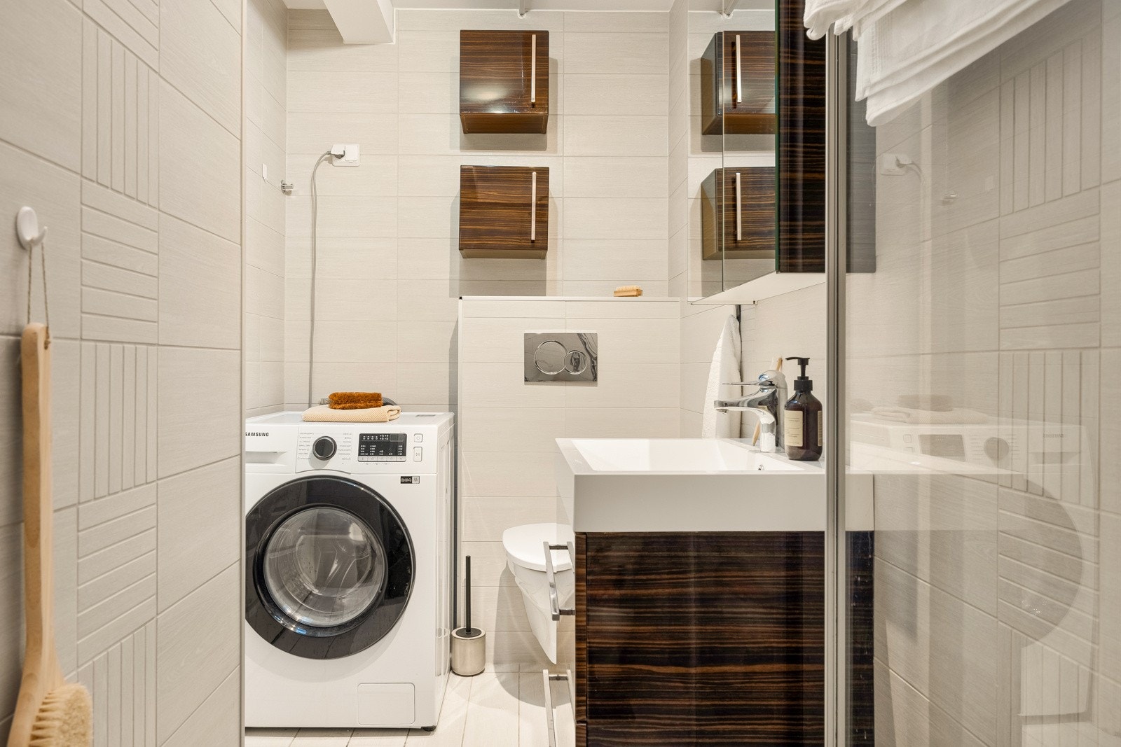 Badet inneholder vegghengt toalett, dusjnisje, opplegg for vaskemaskin og baderomsinnredning med heldekkende servant, speil og belysning. Galleribilde