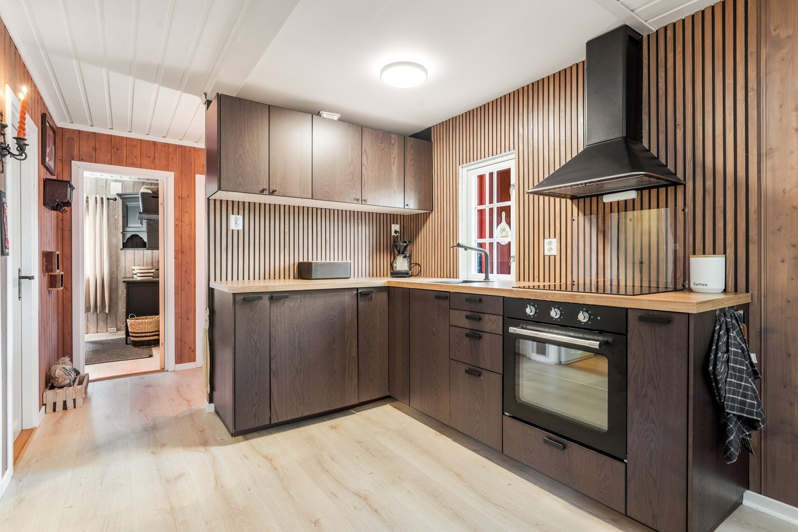 Kjøkkenet har lekker IKEA innredning med glatte fronter og benkeplate av laminat med nedfelt sort vask. Galleribilde