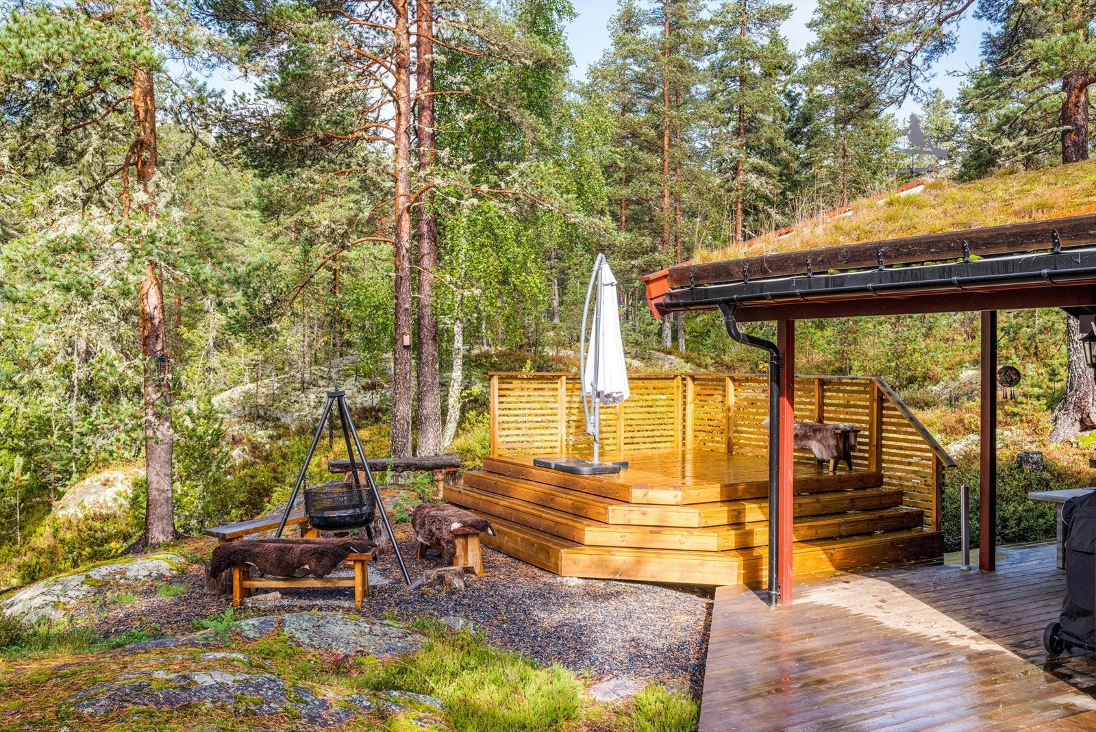 Det er også en oppbygget terrasse med rekkverk på to sider. Samt gruset område ved terrasse med hyggelig bålplass. Galleribilde