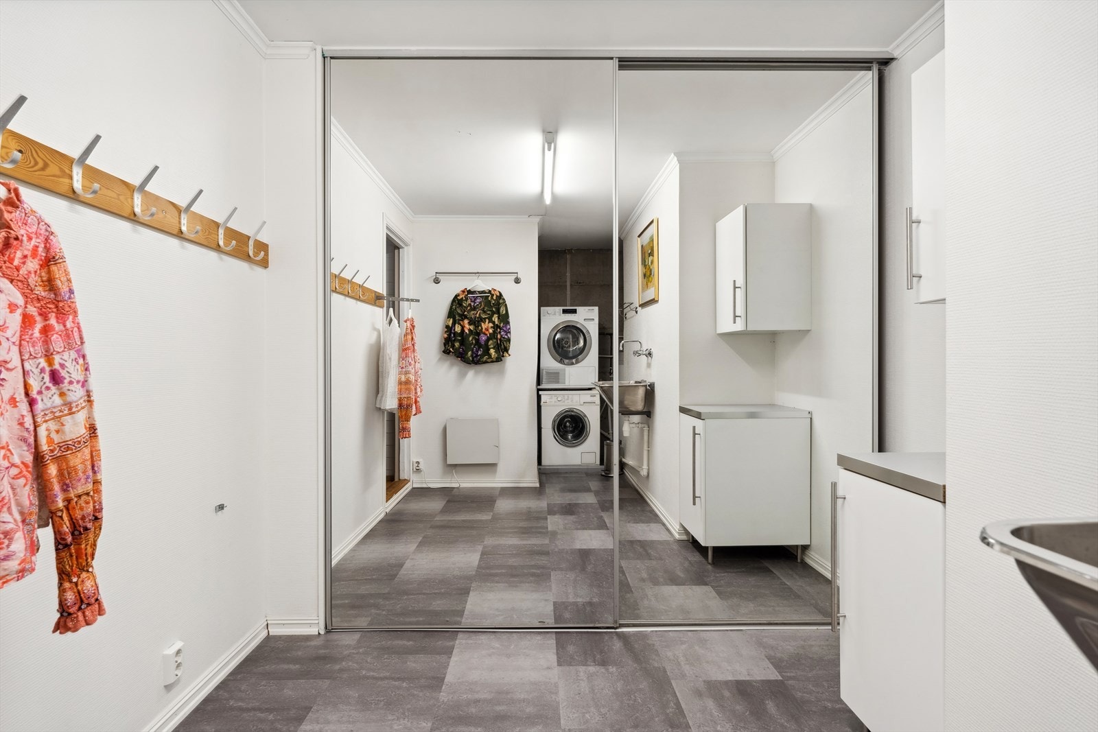 Det separate vaskerommet er innredet med med benker, skap, utslagsvask og opplegg for vaskemaskin samt en skyvedørsgarderobe med speilfronter. Galleribilde