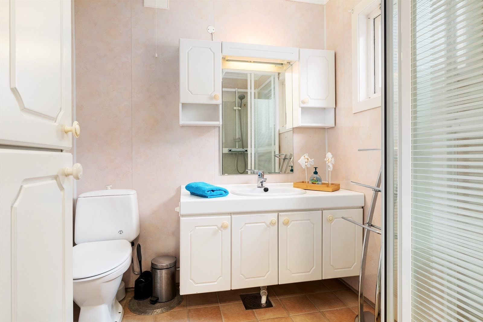 Badet er innreia med toalett, dusjkabinett, servant med oppbevaring. Galleribilde