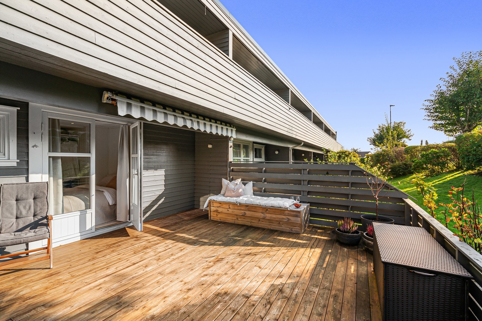 Treverket og detaljene på terrassen skaper et hyggelig utendørsområde, ideelt for solfylte dager. Galleribilde