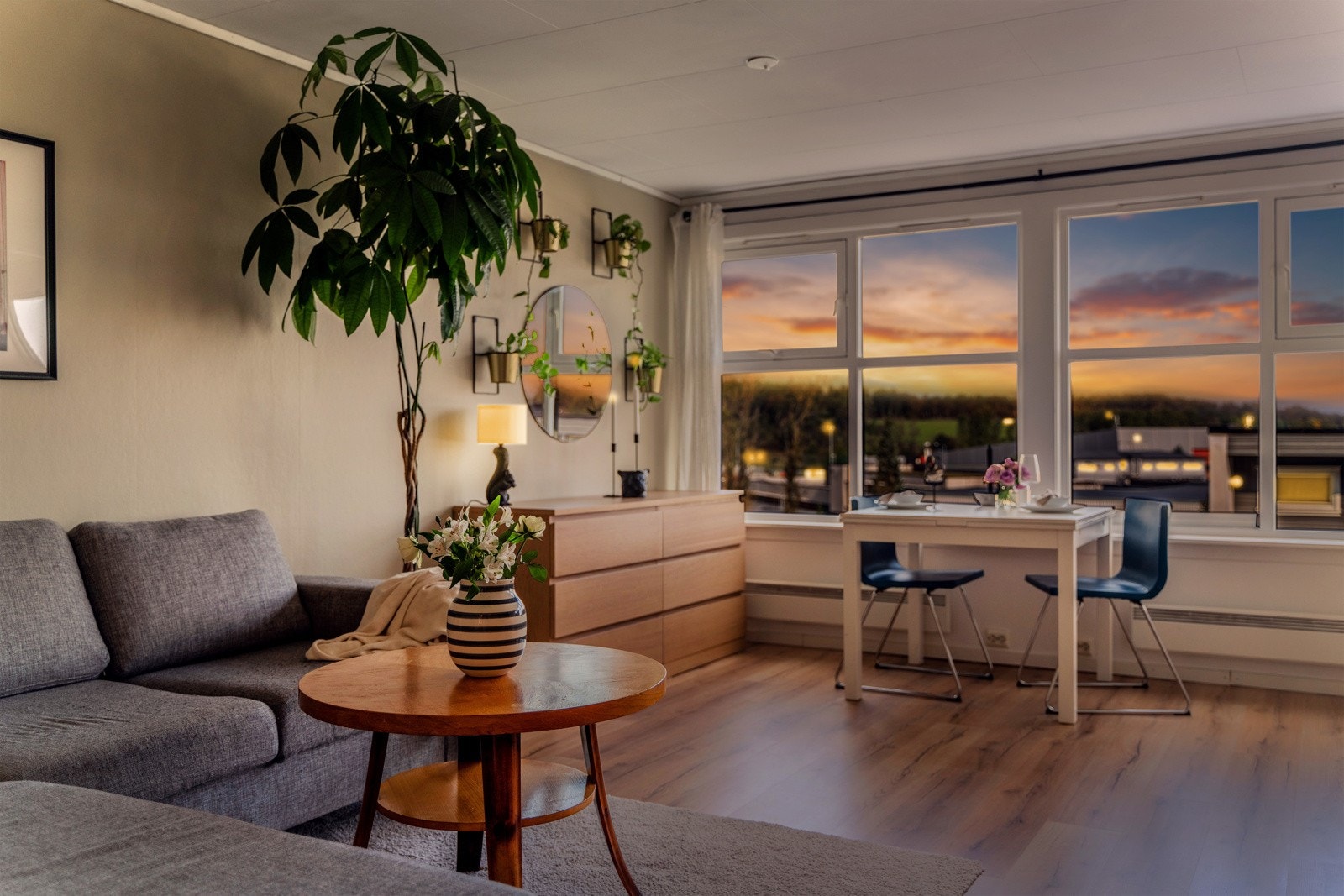 Stuen badet i kveldssol gir et varmt og innbydende inntrykk med store vinduer som slipper inn naturlig lys. Galleribilde